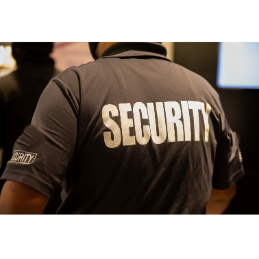 Back of a security guard wearing a dark uniform with the word 'SECURITY' in large white letters.
