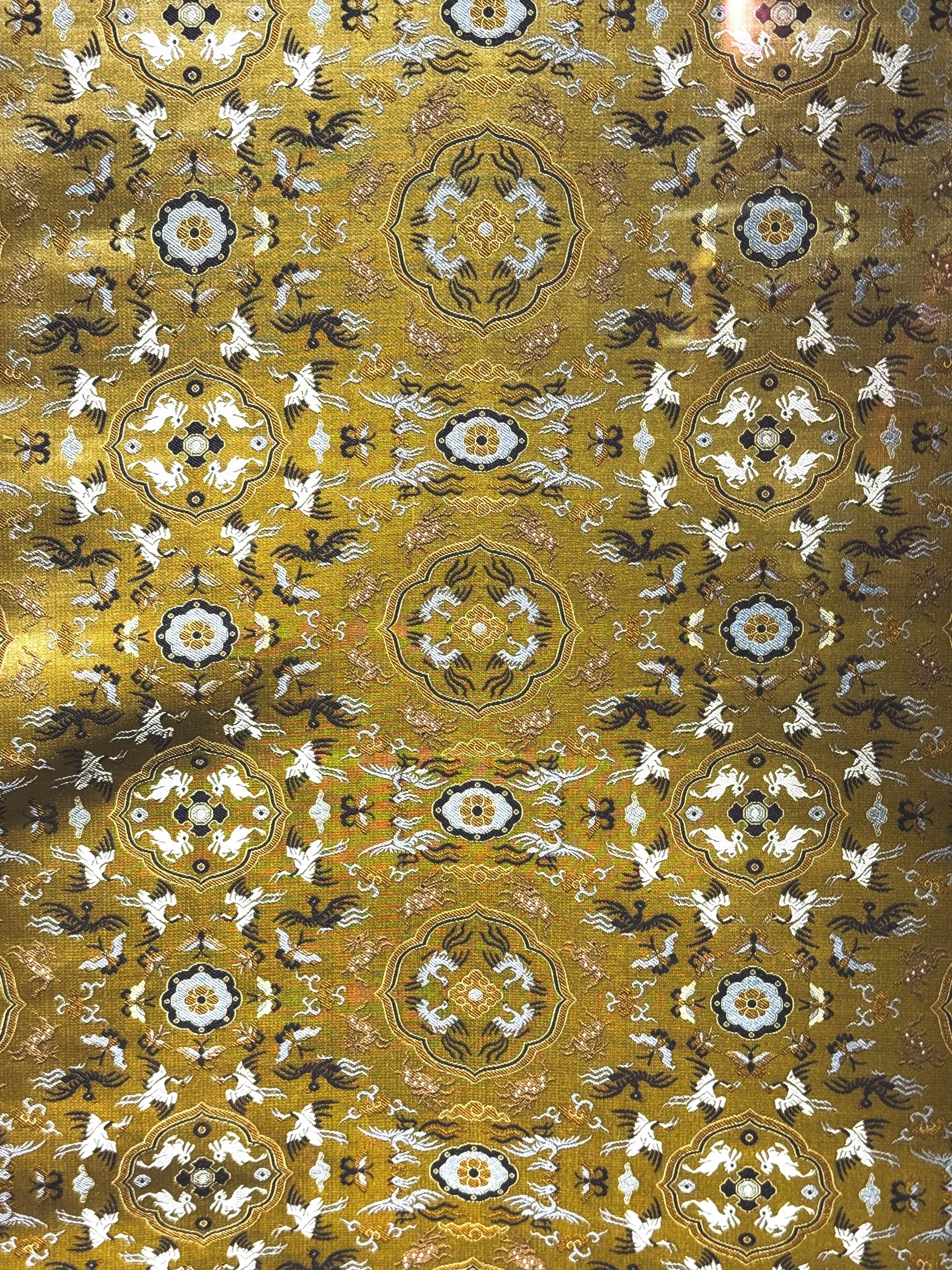 Macro detail of Shu brocade: gold silk with woven cranes and medallions.