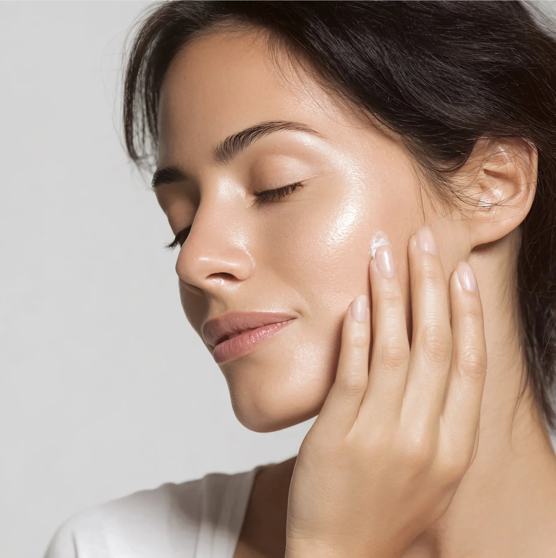 woman with smooth blemish free skin touching her face.
