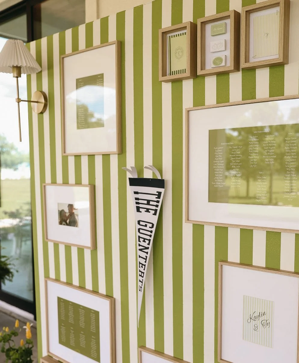Decorative wall with framed pictures, green and white striped wallpaper, a wall-mounted lamp, and a golf-themed decoration with the words "TEE CRESENT".