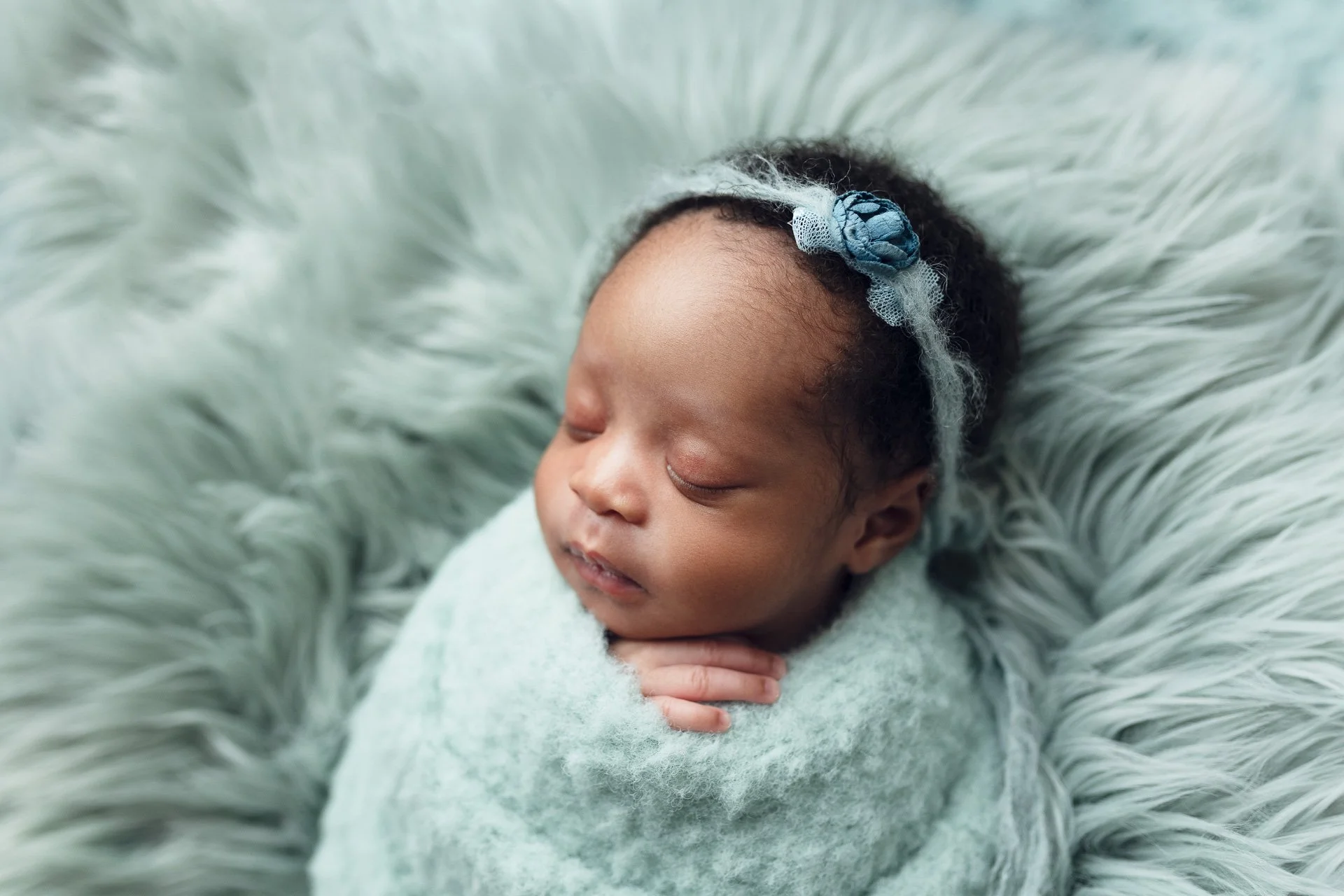 Mint green fluffy wrap and matching headband are adorable on this newborn baby girl for her photoshoot with Sophie Lecavalier Photography in Victoria BC