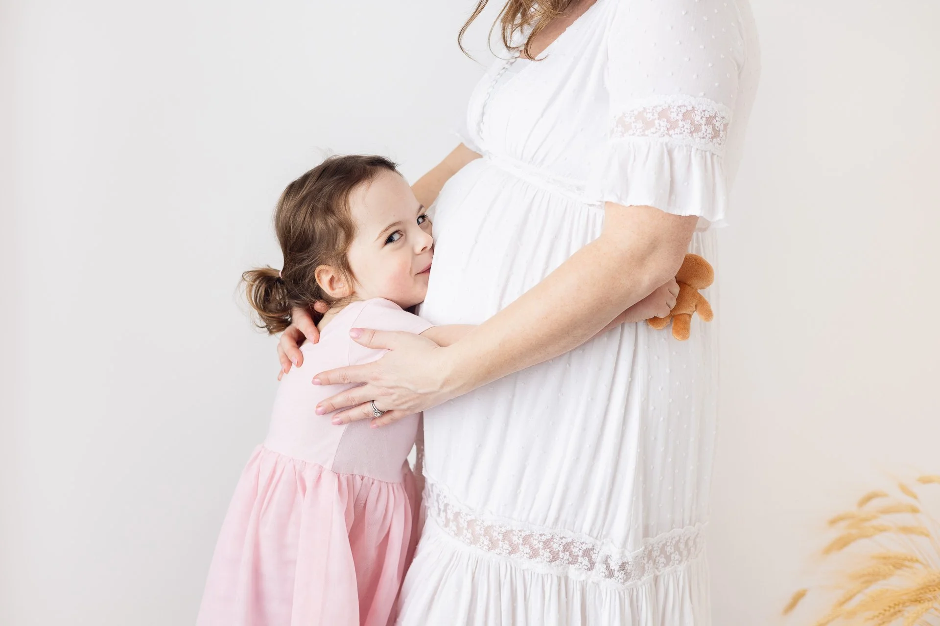 Light and airy Maternity session with older sibling snuggling with her mom. Studio Maternity photo shoot in Saanich BC