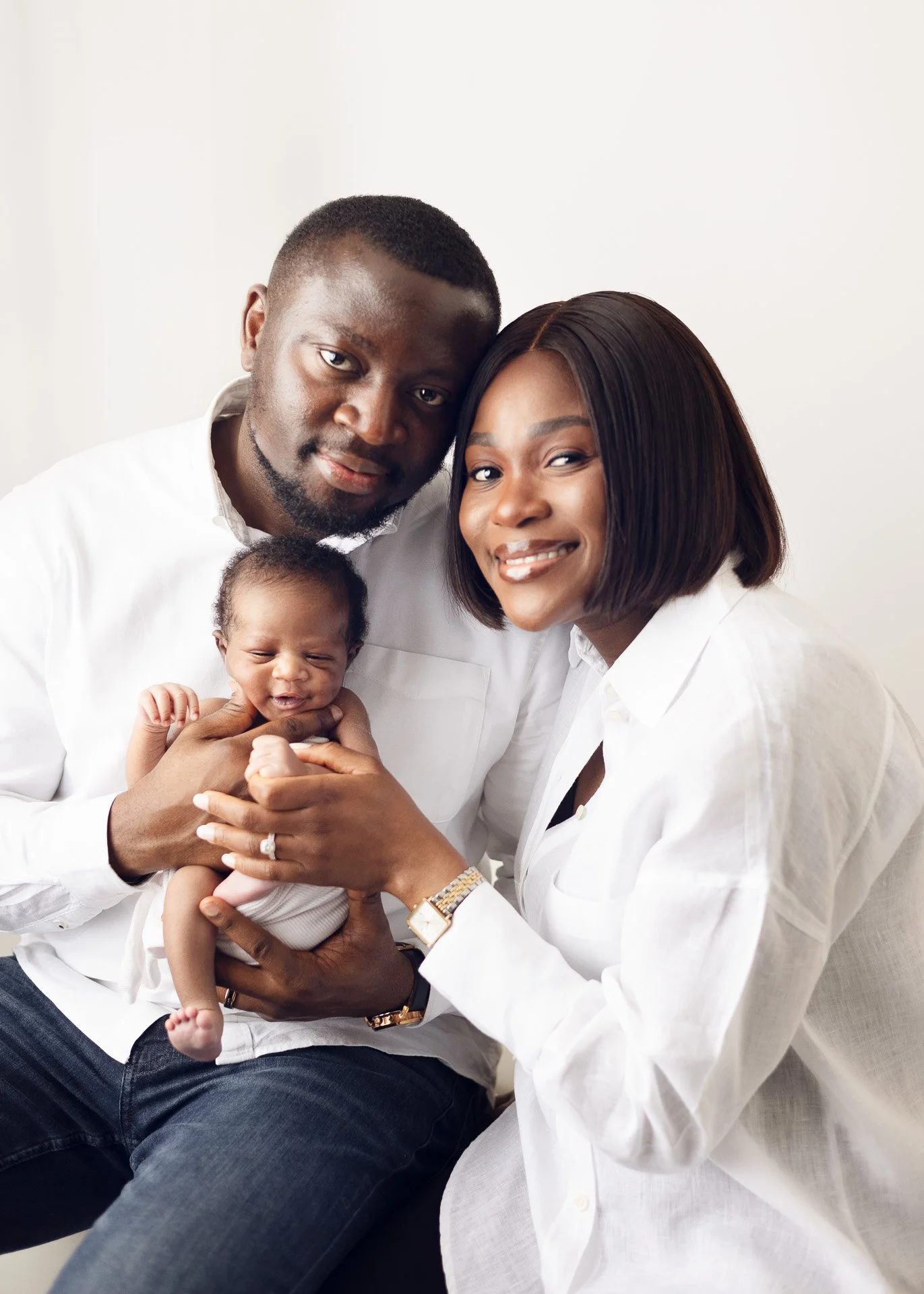 Studio family newborn photoshoot in Victoria BC Light and airy backdrop for mom dad and baby snuggling together