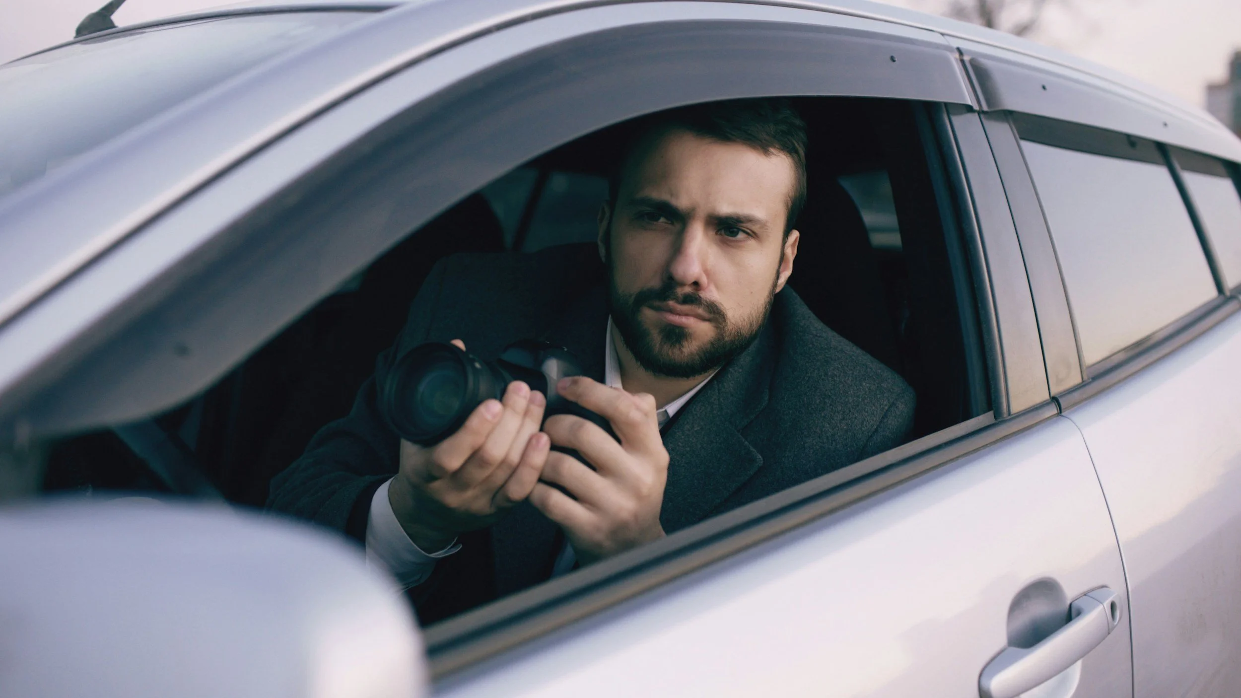 Private investigator conducting surveillance from a vehicle