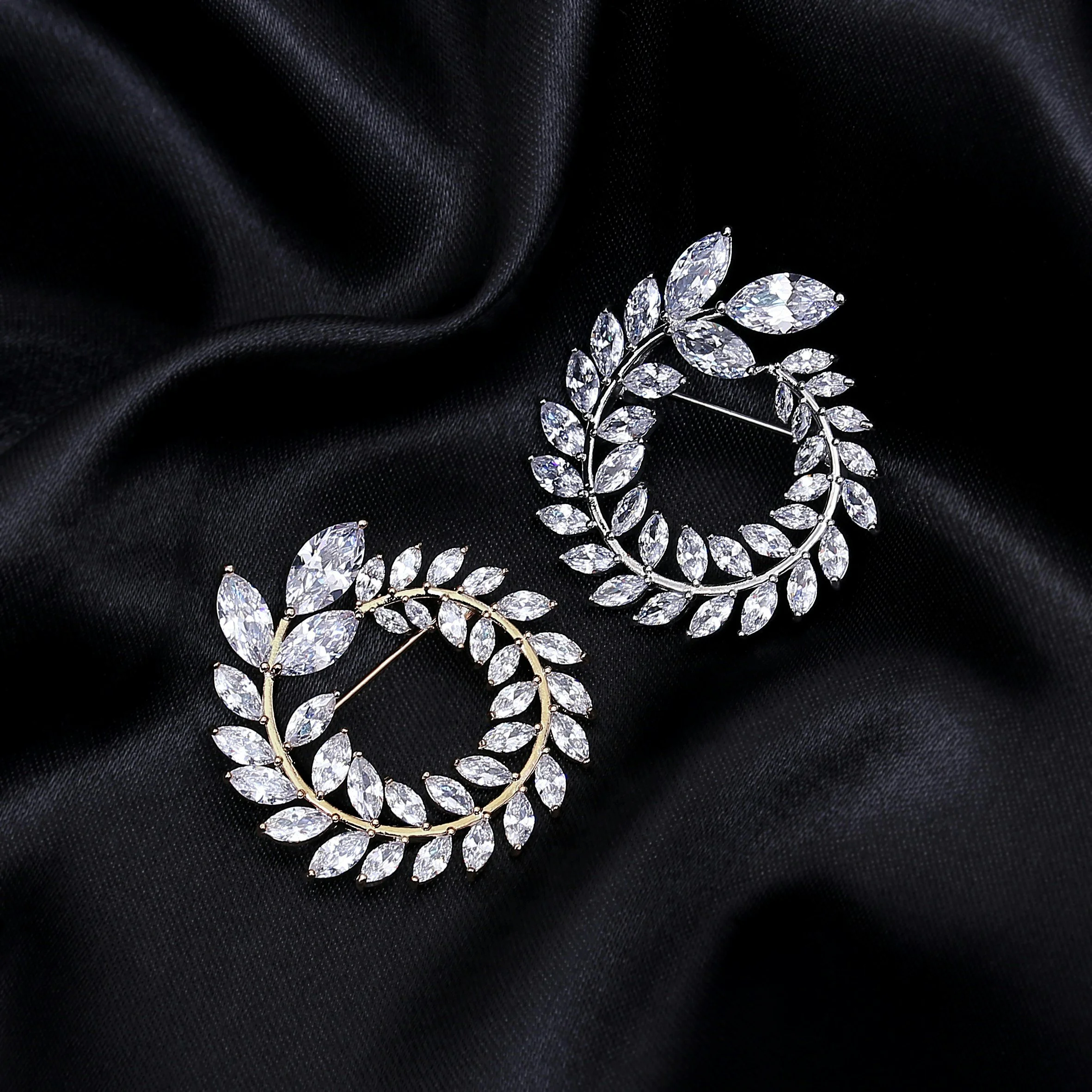 A sparkling jewelry necklace with leaf-shaped crystals, resting on black fabric.