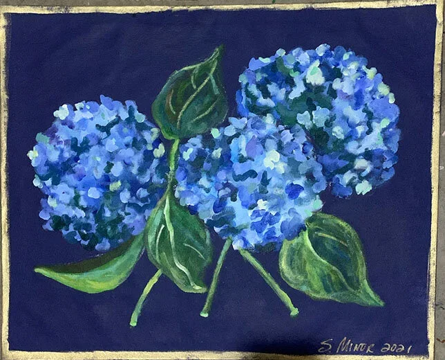 Painting of three blue hydrangea flowers with green leaves on a dark background, signed by S. Minker in 2021.