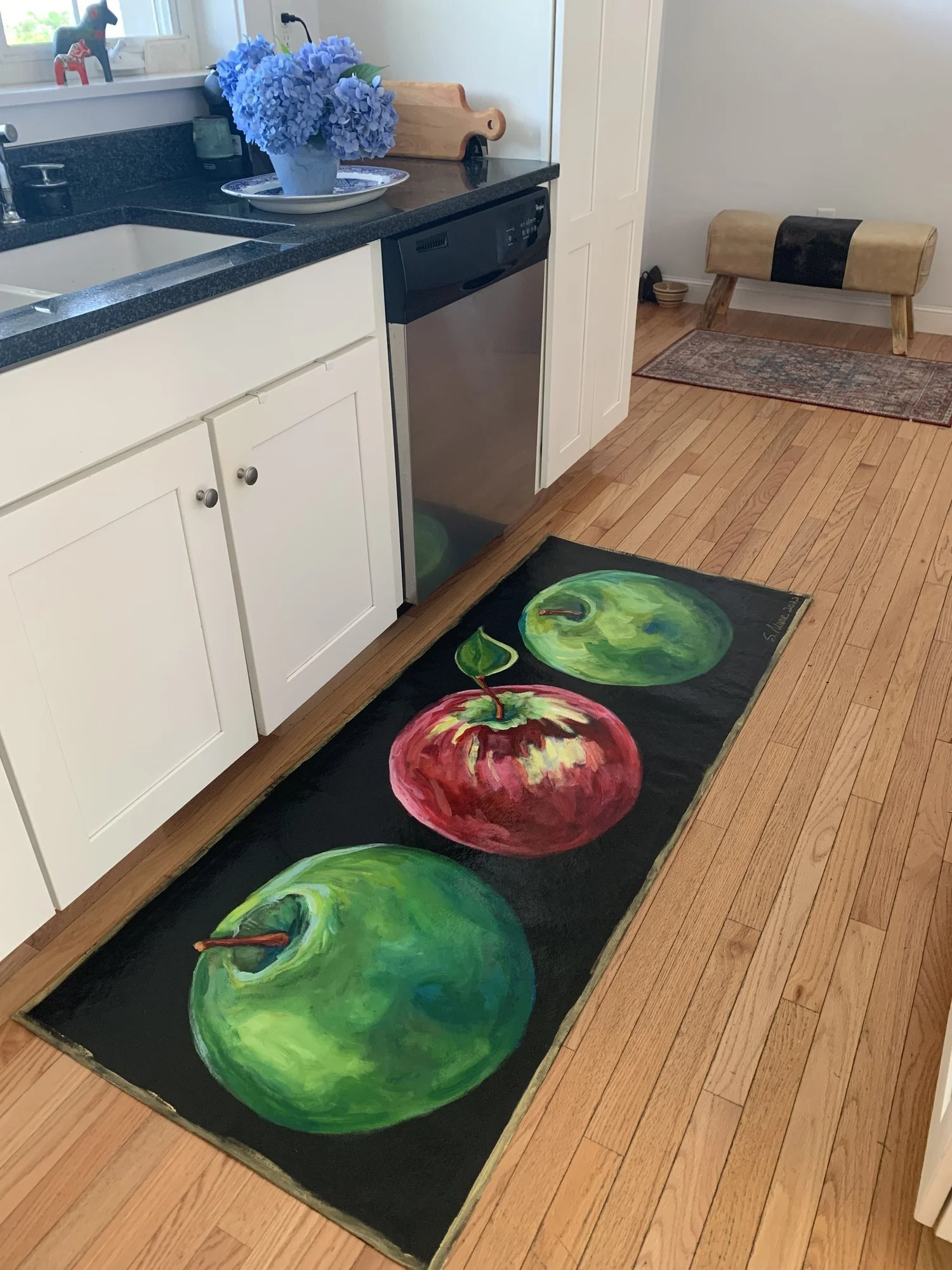 Kitchen with hand-painted canvas runner of assorted apples on black background