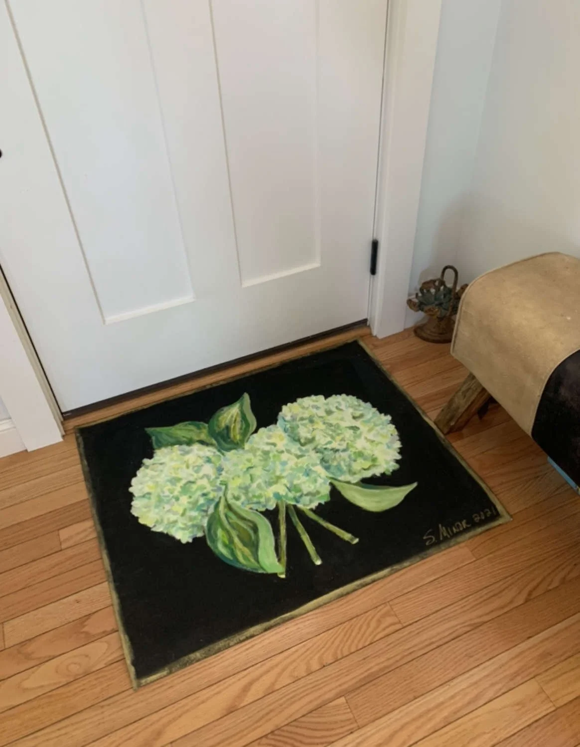 Door area with hand-painted canvas floorcloth of hydrangeas on black background