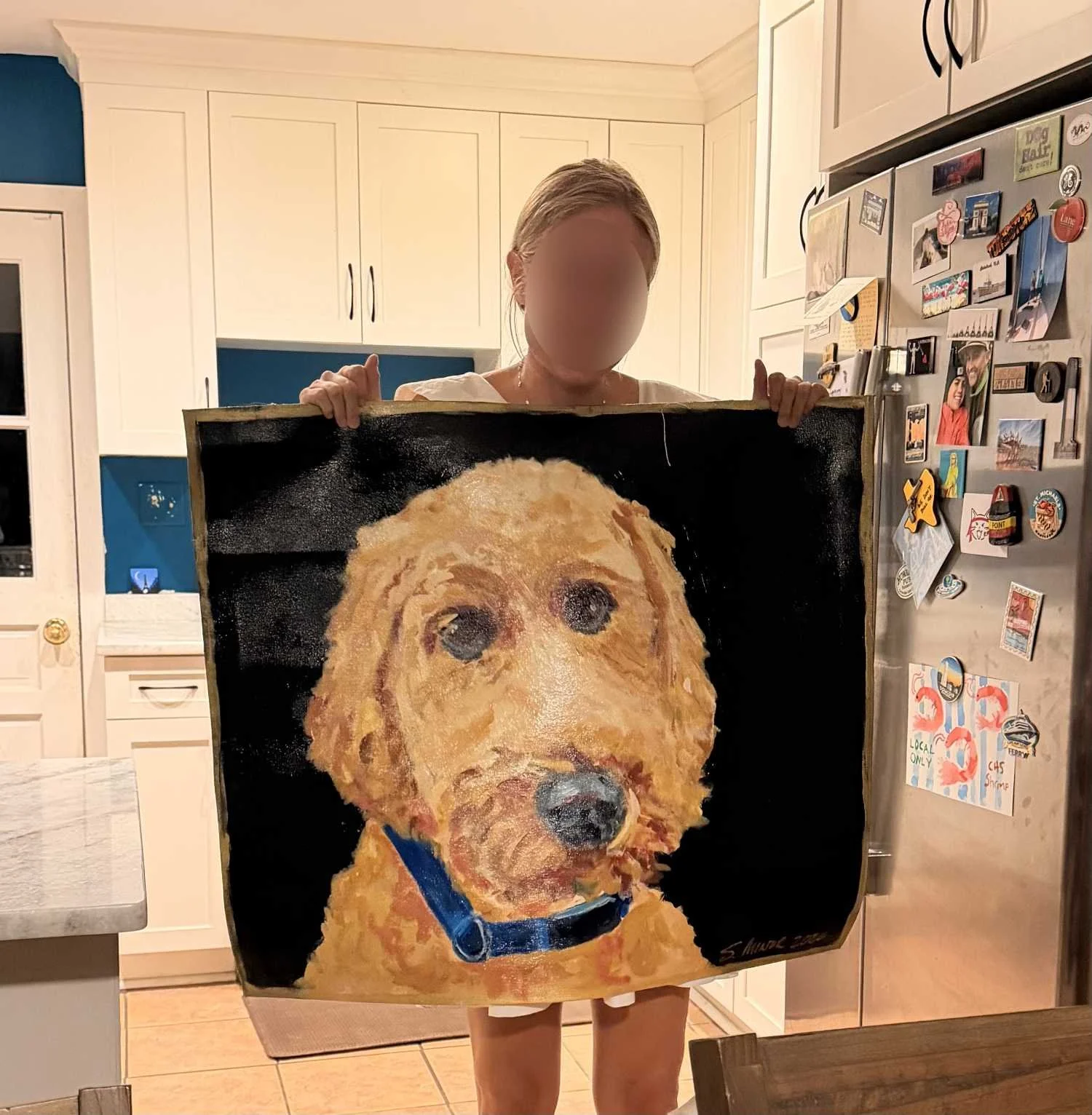 Owner holding a hand-painted canvas floorcloth of her dog in a kitchen.