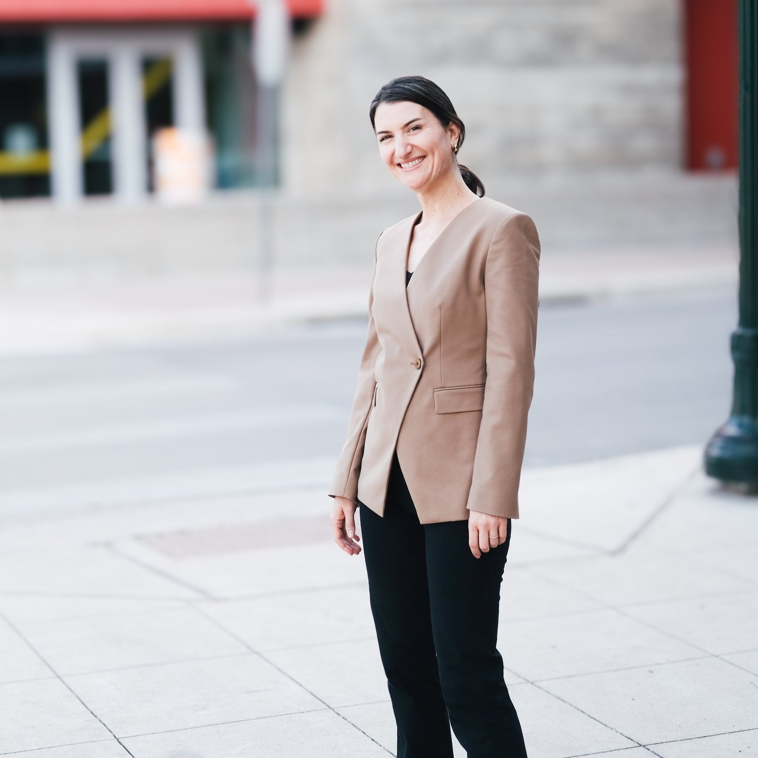 Maureen Brown, founder of Exit with Mo, smiling on a city sidewalk