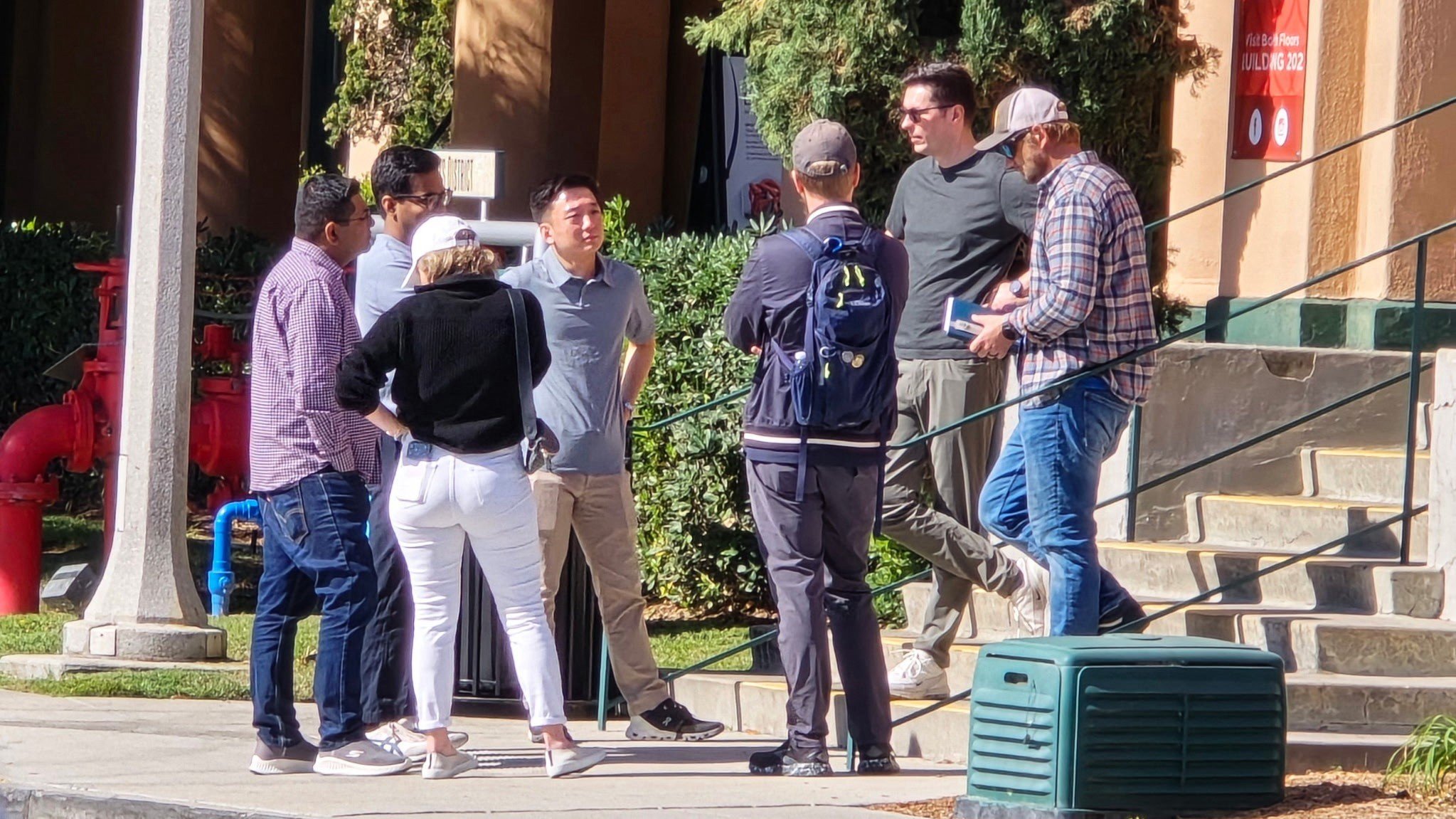 Corporate professionals conduct a structured debrief after a surveillance training mission, reviewing decisions, communication, teamwork, and lessons learned from the experiential exercise.
