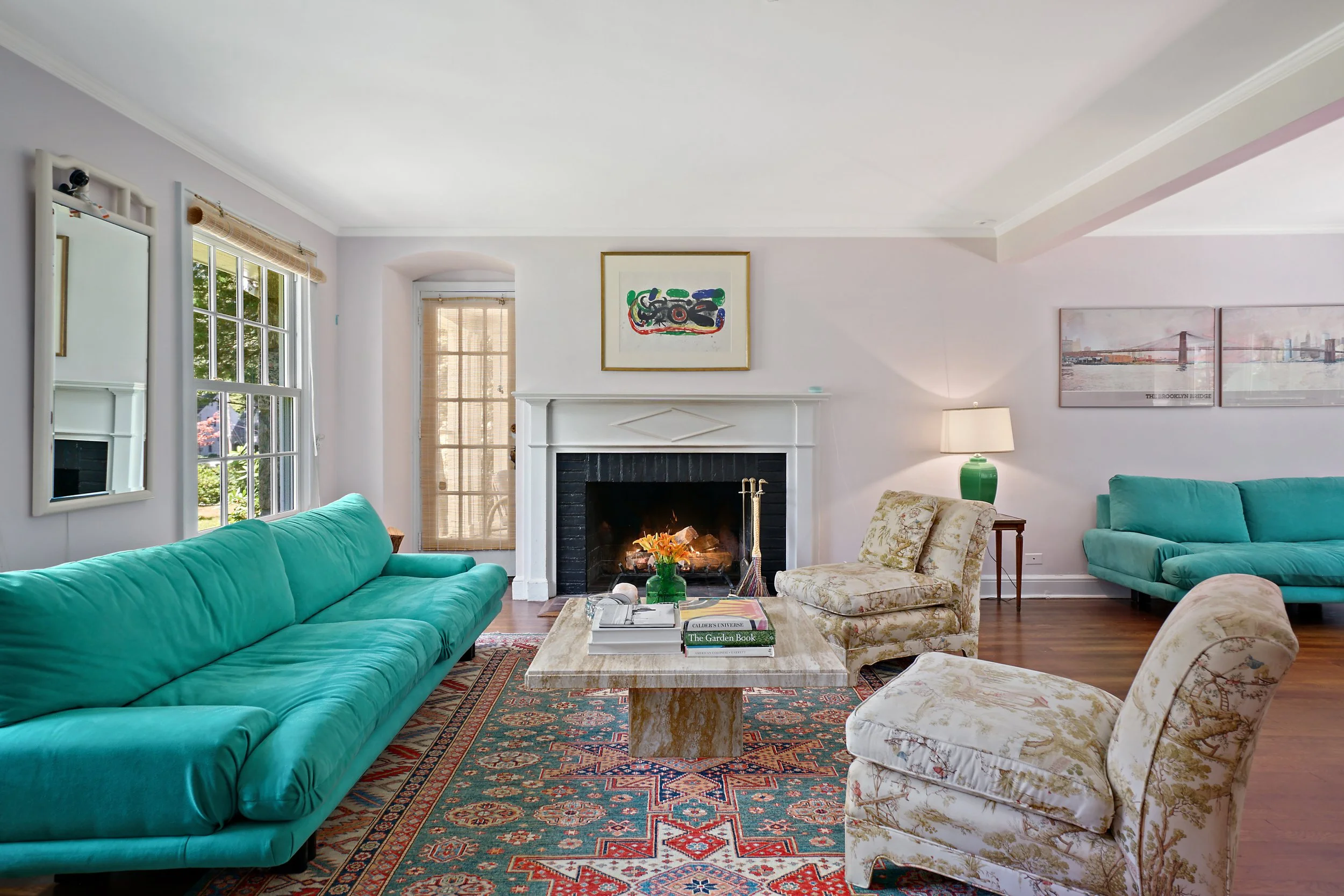 Living room Thayer Coggin ultrasuede sofas from 1988 , Billy Baldwin slipper chairs, fireplace, colorful area rug, travertine marble vintage cocktial table, vintage sarouk rug, Miro lithograph