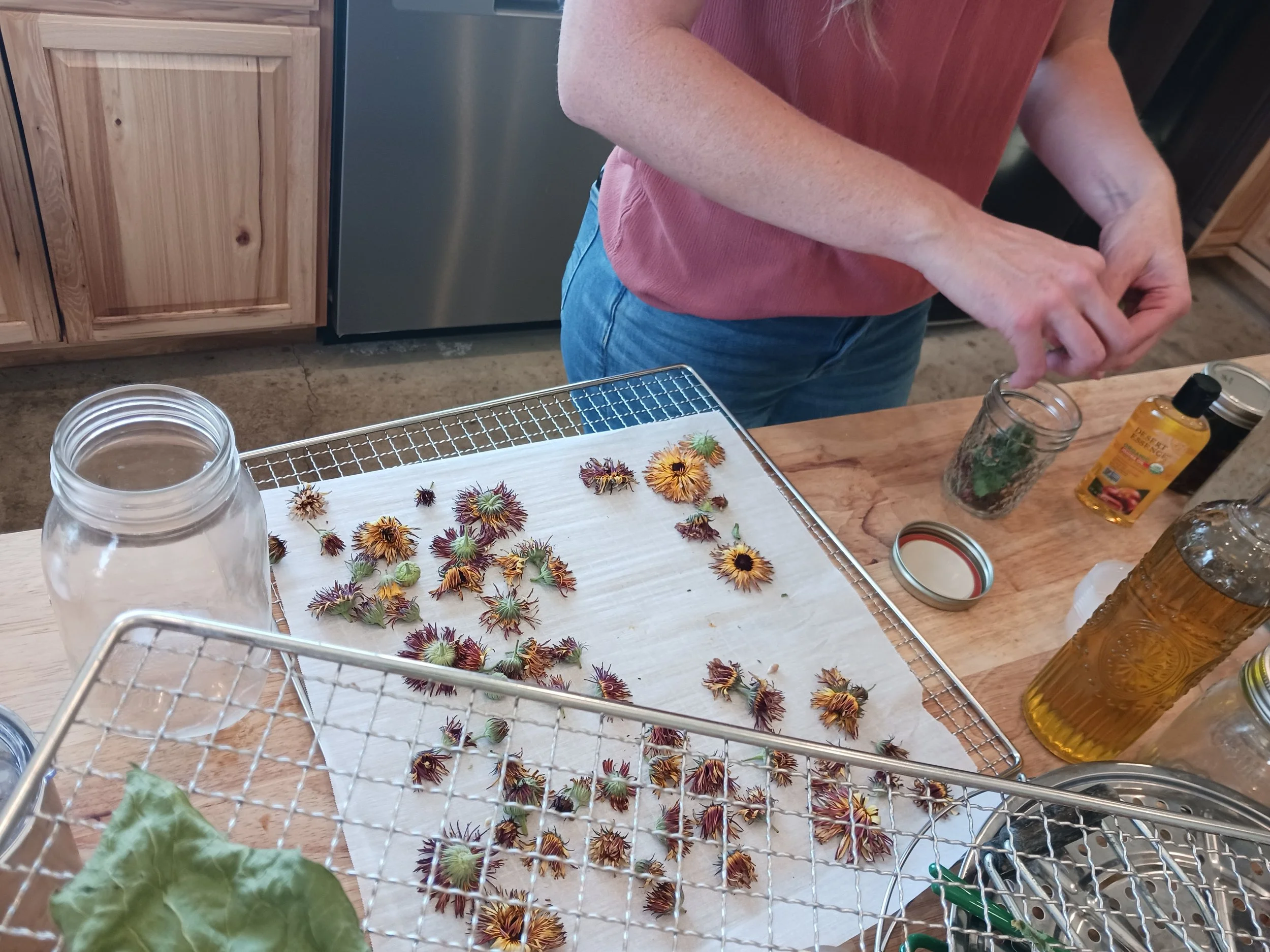 A woman teaching how to make infused oils in class.