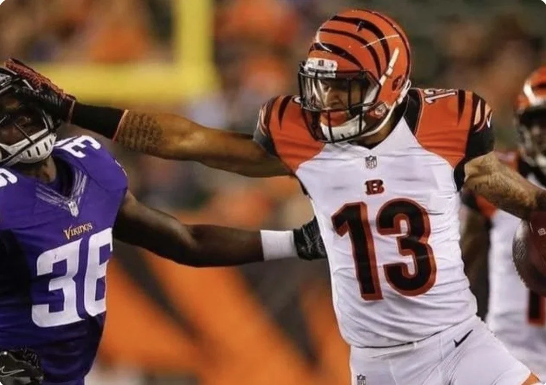 Rashaun Simonise carrying the football for Cincinnati and fending off a defender