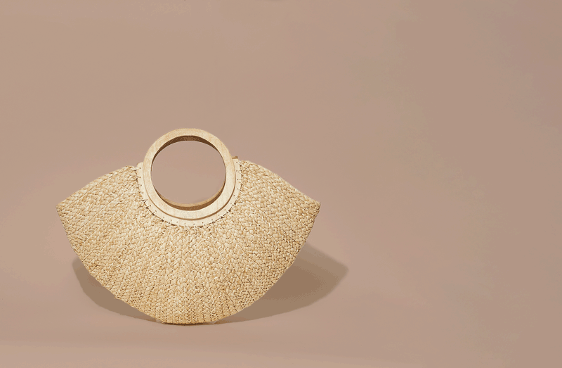 A beige woven handbag with round handles, placed on a light background.