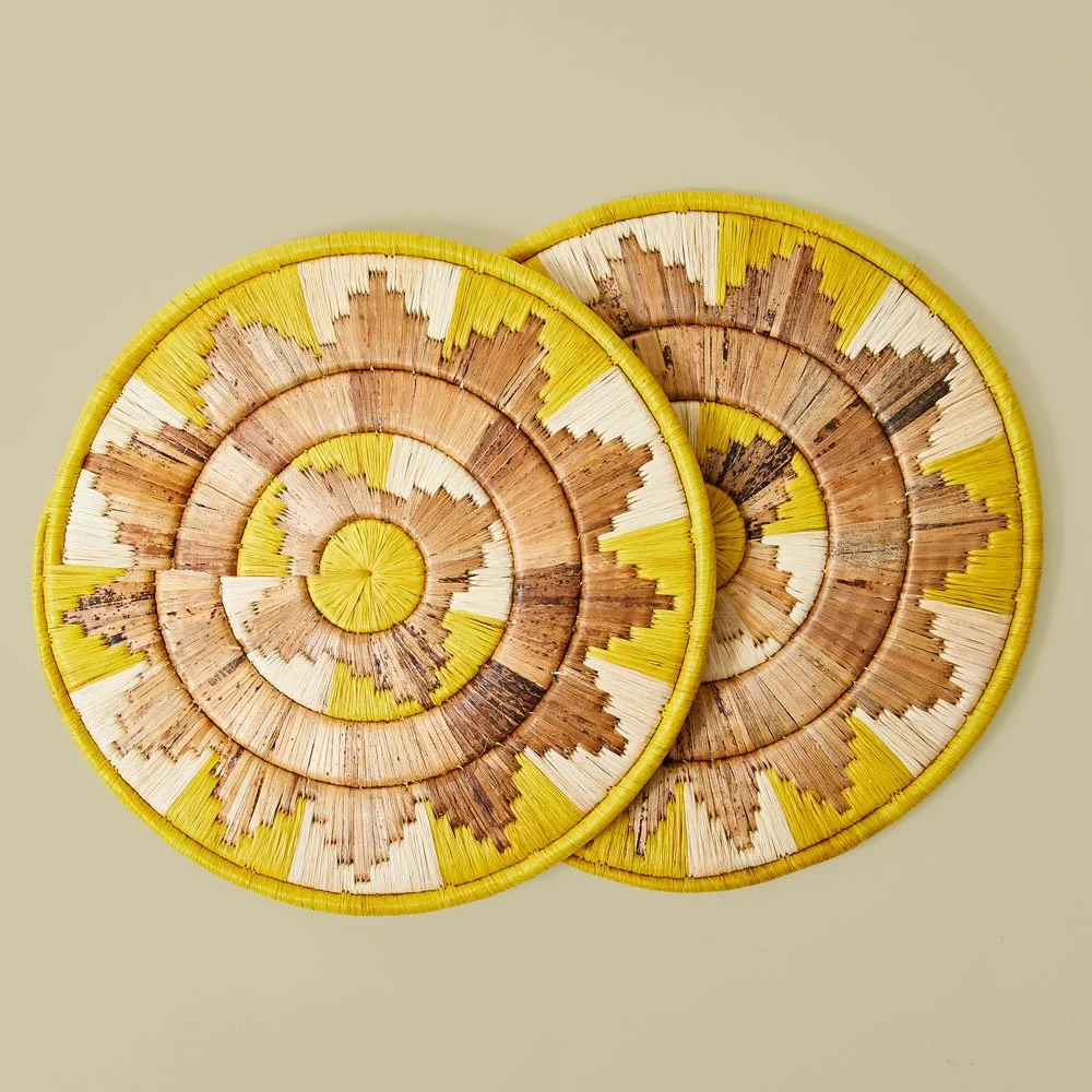 Two decorative spiral-patterned wall hangings made of wood and yellow border accents.