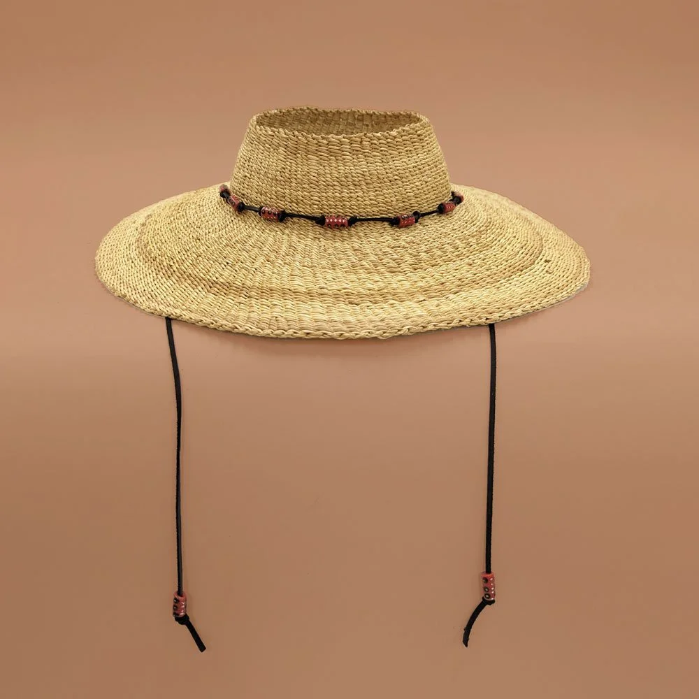 A straw sun hat with adjustable chin straps and a beaded band around the crown, displayed against a plain background.