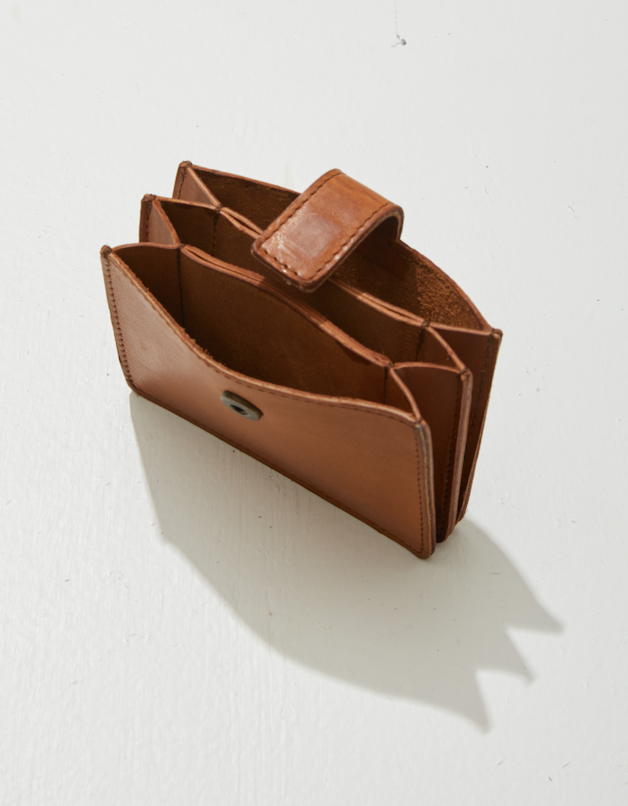Empty brown leather wallet on white surface with shadow.