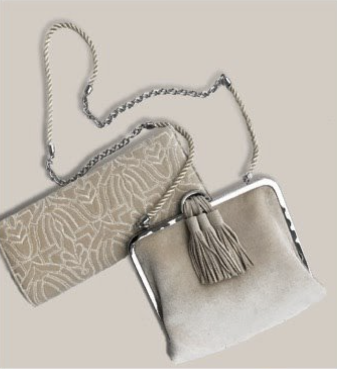 Two beige handbags with chain straps and tassel accents, one with a patterned surface and the other with a suede-like finish, positioned on a plain background.
