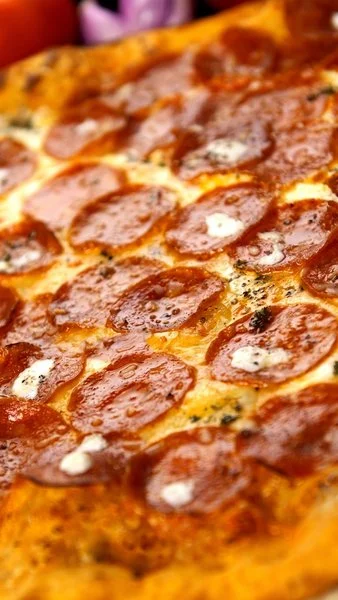 Close-up of a pepperoni pizza with melted cheese and spicy pepperoni slices.