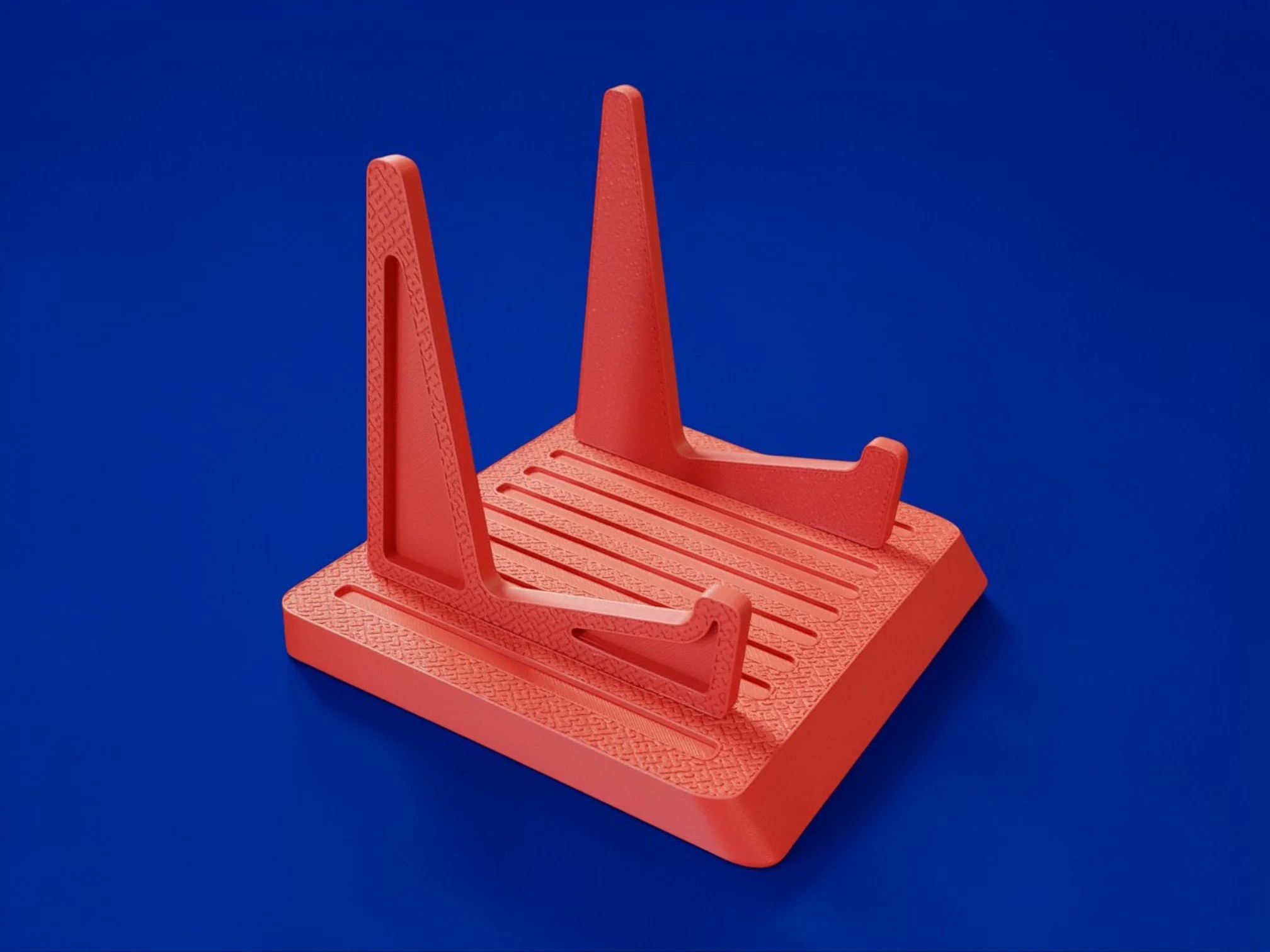 Red plastic chair with a perforated seat and tall backrest against a solid blue background.