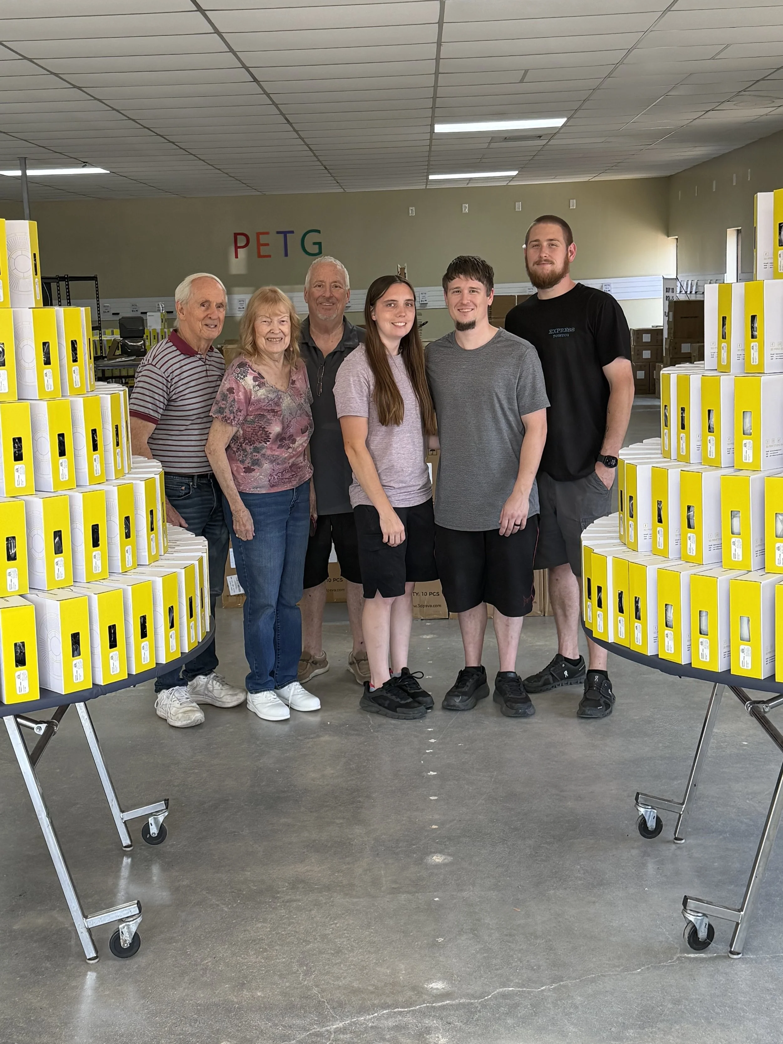 3D Print Studio of VA team visiting a filament warehouse surrounded by boxes of PETG filament.