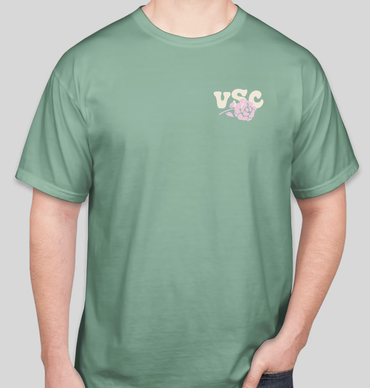 A green T-shirt with a small logo on the left chest that includes the letters "VSC" and a pink flower.