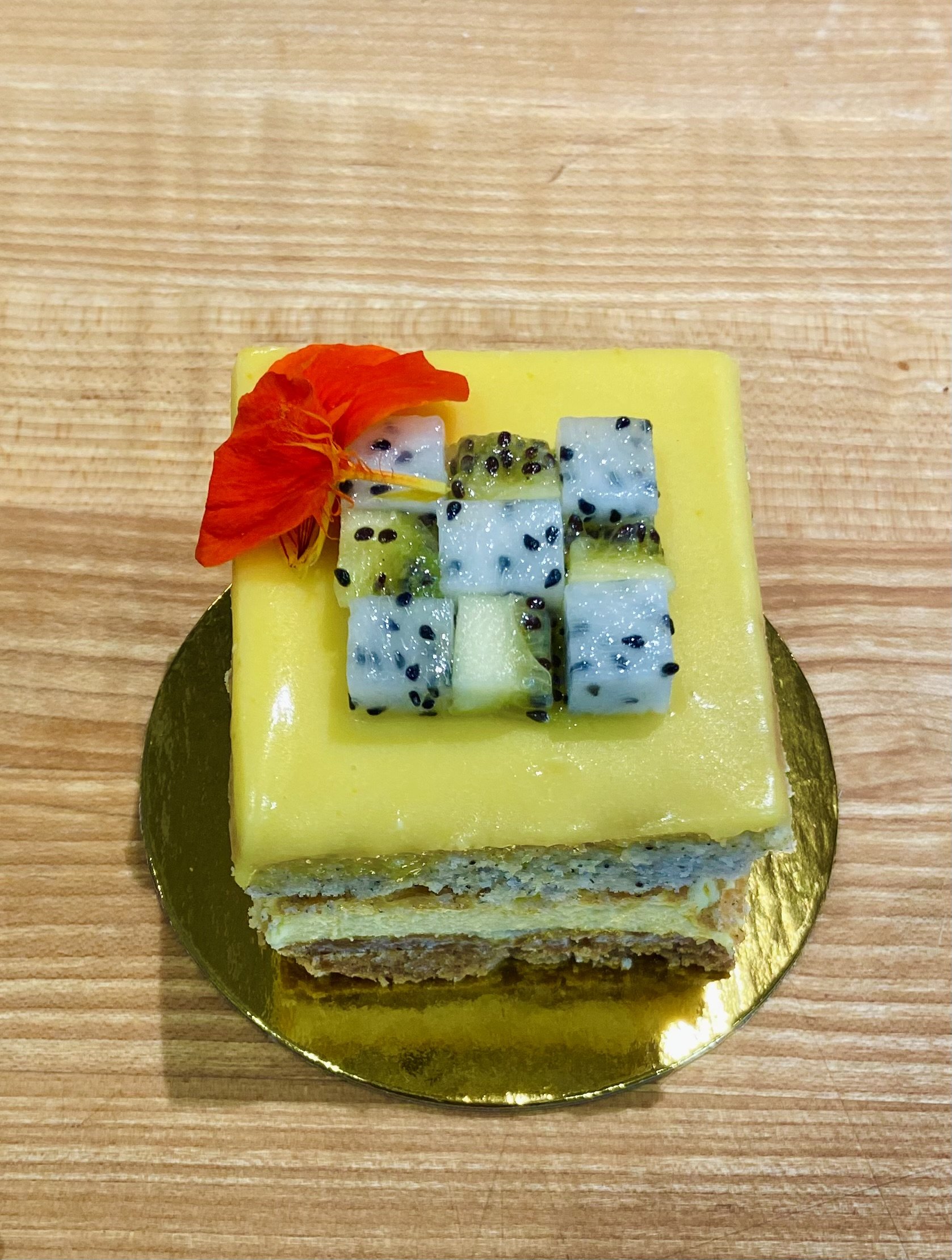 passionfruit, black sesame and tropical fruit cake slice
