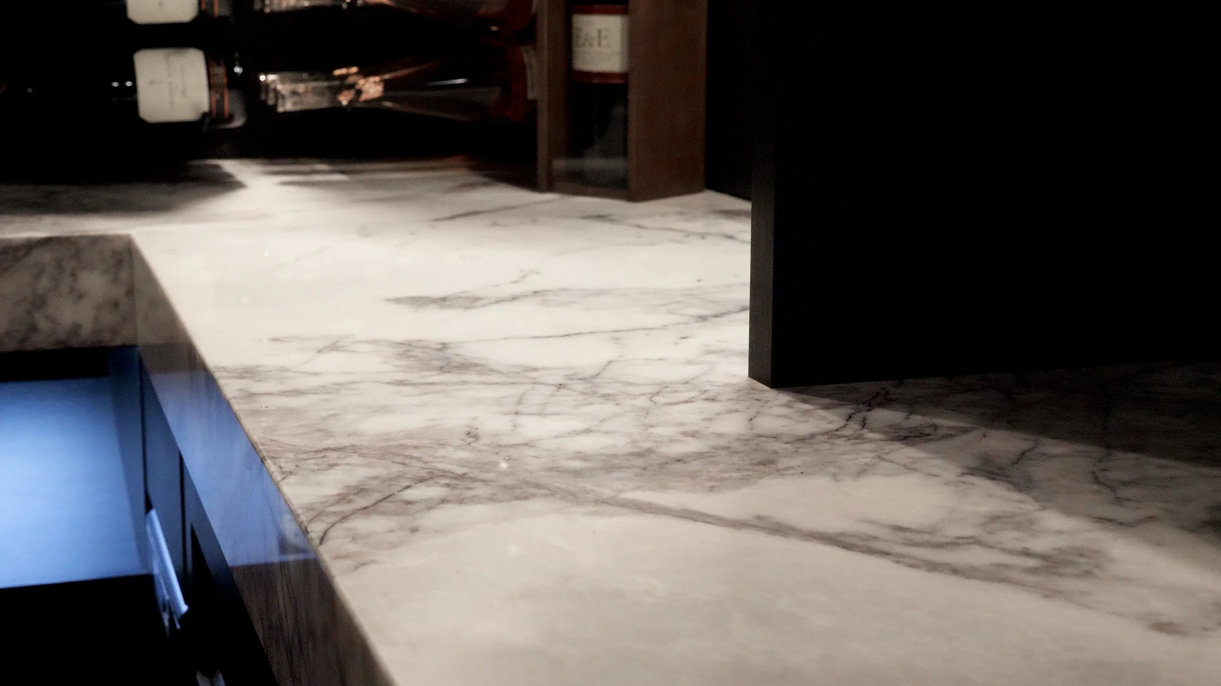 Close-up of a marble countertop with gray and white veining in a kitchen area.