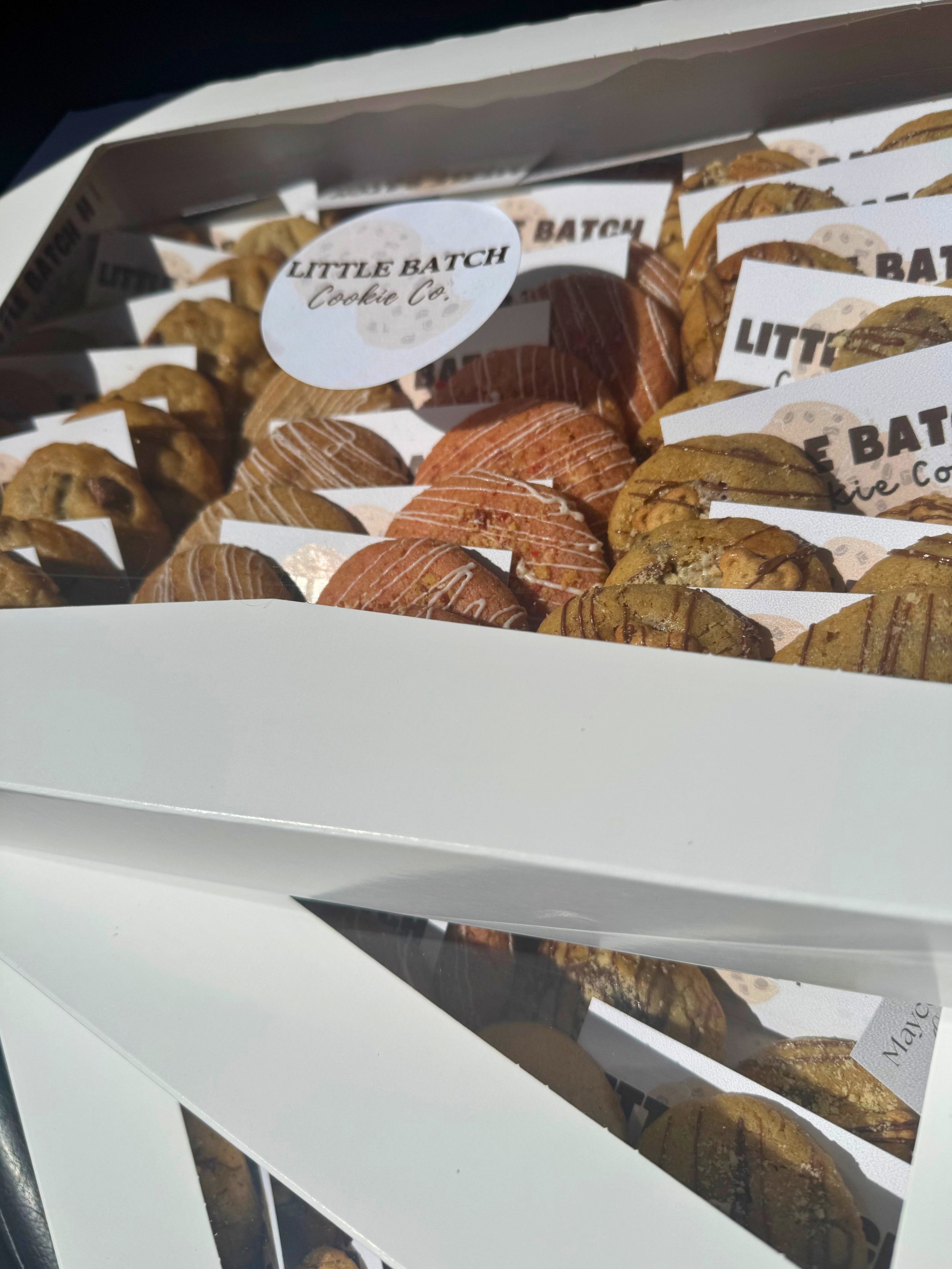 Assorted cookies in bakery boxes with a label reading 'Little Batch Cookie Co.'.