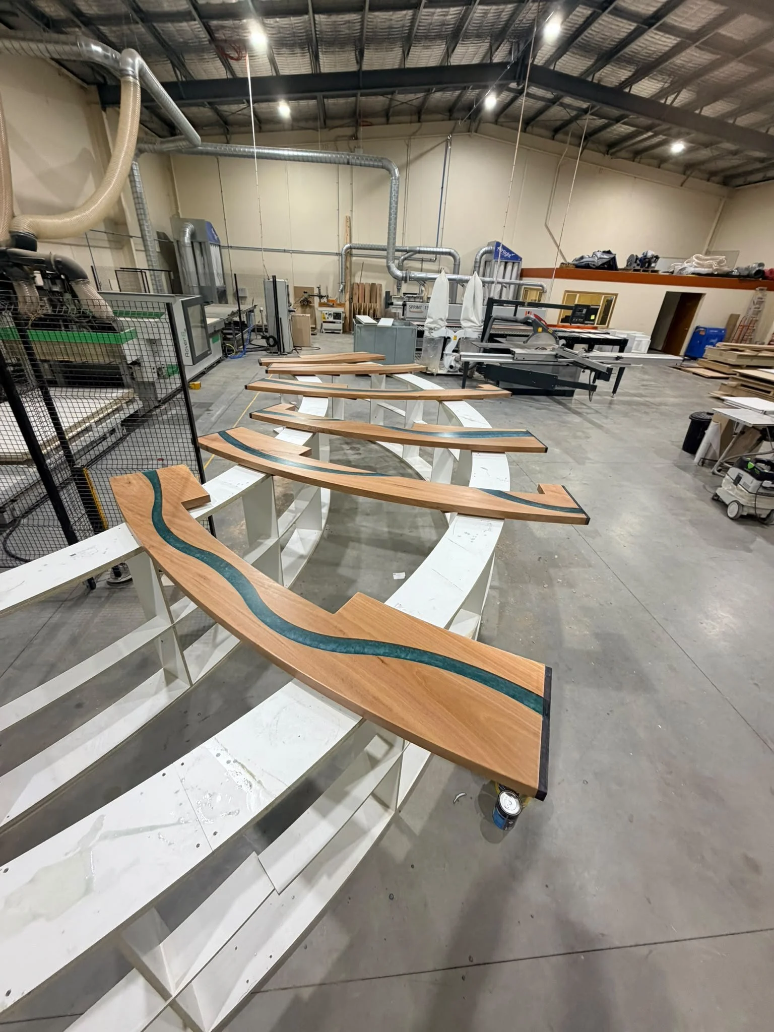 Step 7: finished curved bartop sections lined up on racks in the Finecraft workshop, ready for wrapping and delivery.
