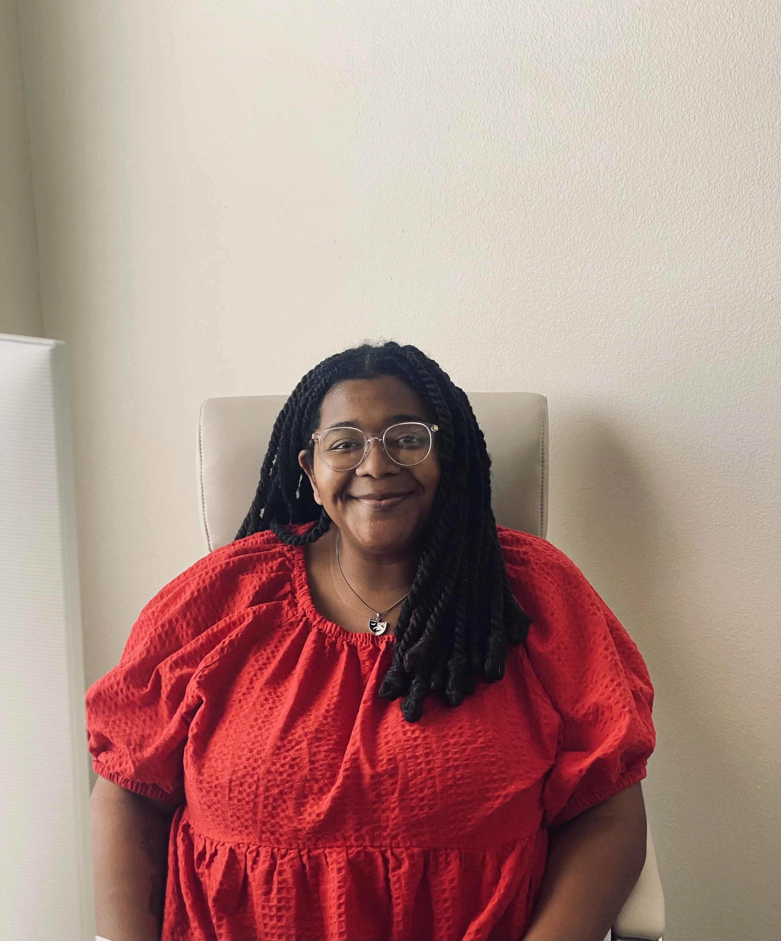 Trinity Perry smiling in a red blouse.