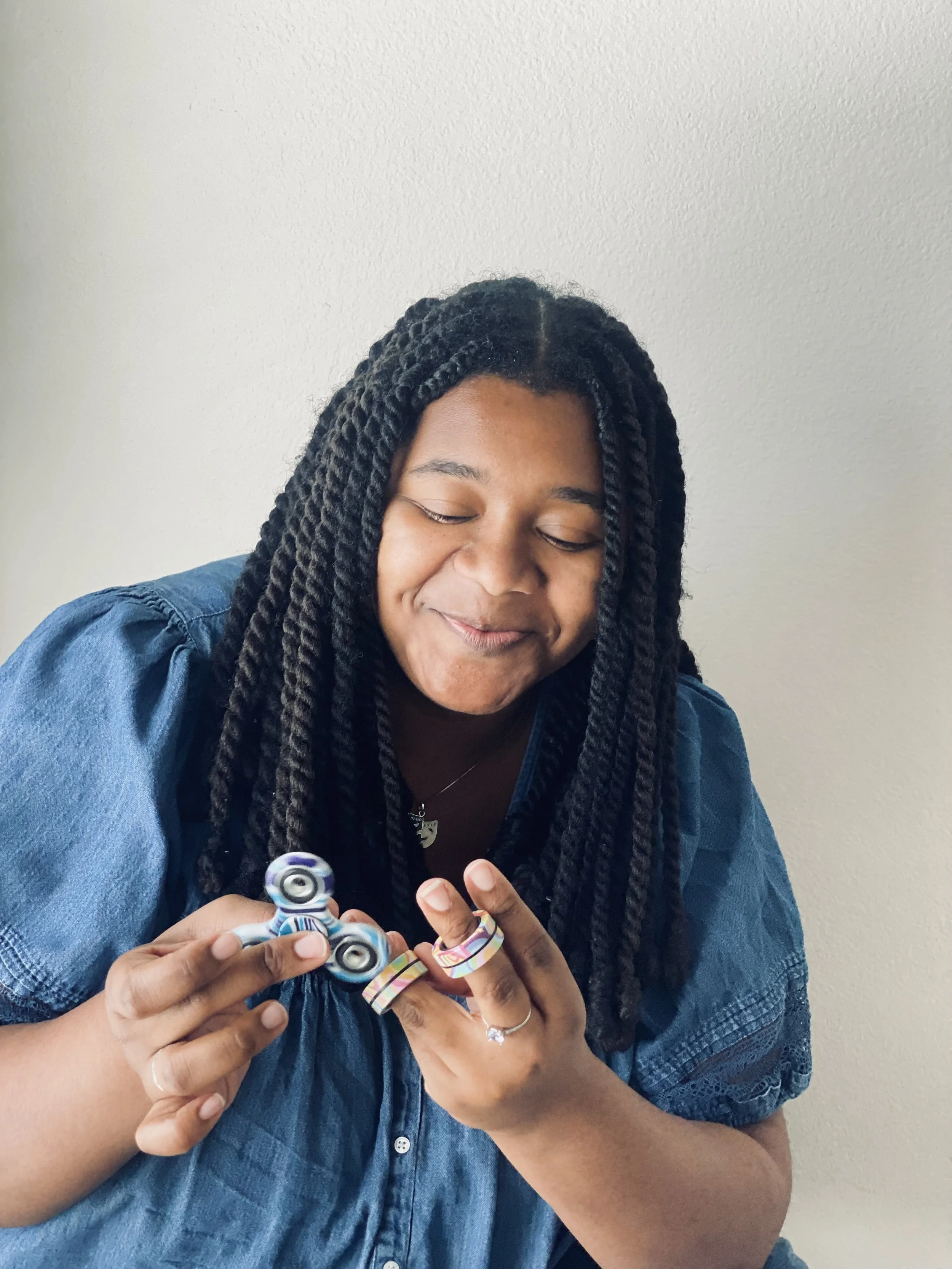 Trinity Perry smiling while holding a colorful fidget toy.