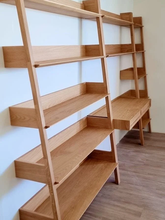 Empty wooden bookshelves with multiple shelves and a desk attached to one of the shelves.