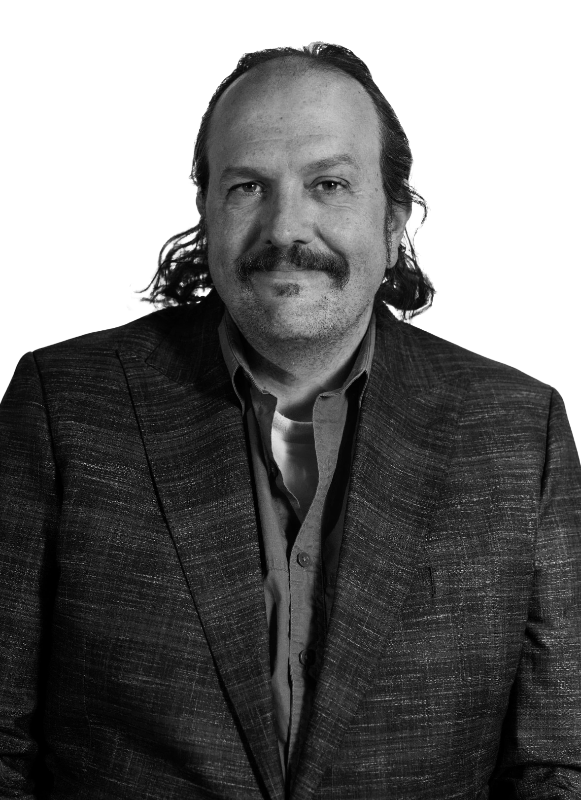 Black and white portrait of a middle-aged man with shoulder-length hair, a mustache, and a goatee, wearing a plaid blazer and shirt.