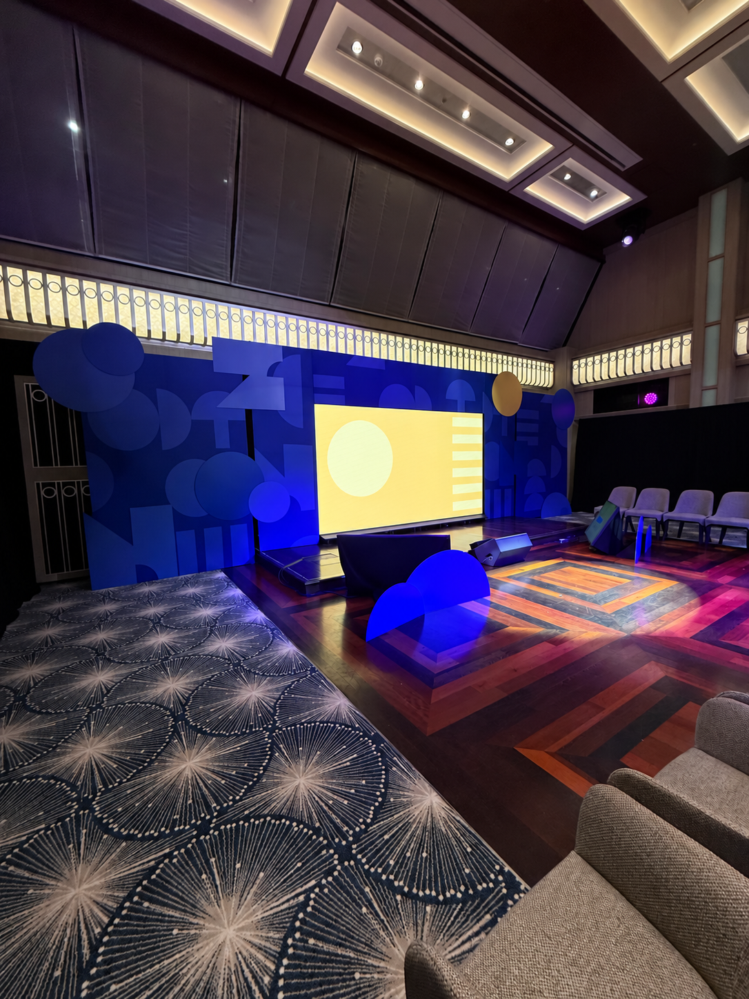 Geometric blue-lit stage with yellow screen (2).png