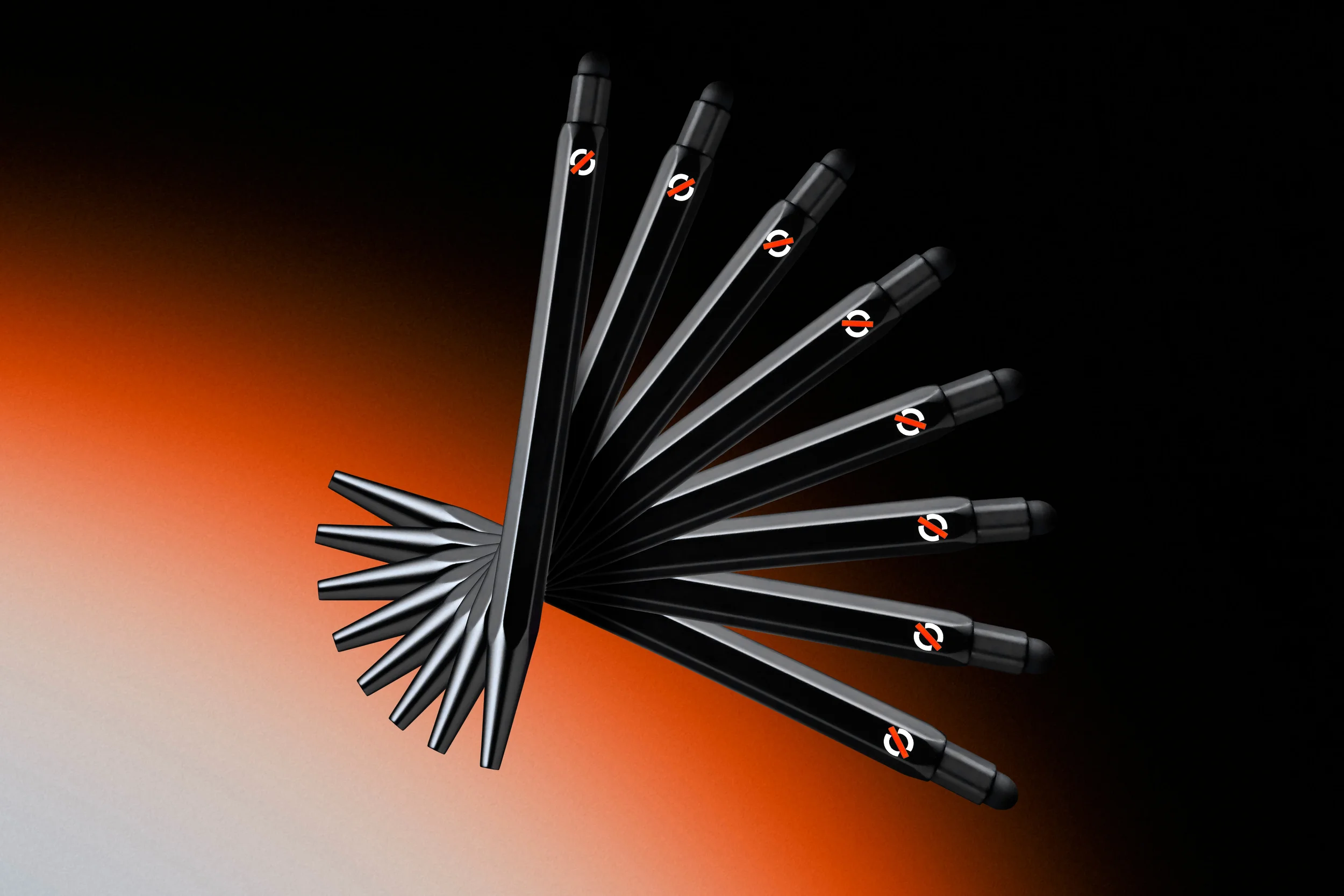 Une collection de stylos noirs disposés en cercle avec un dégradé de couleur de l'orange au gris en arrière-plan.