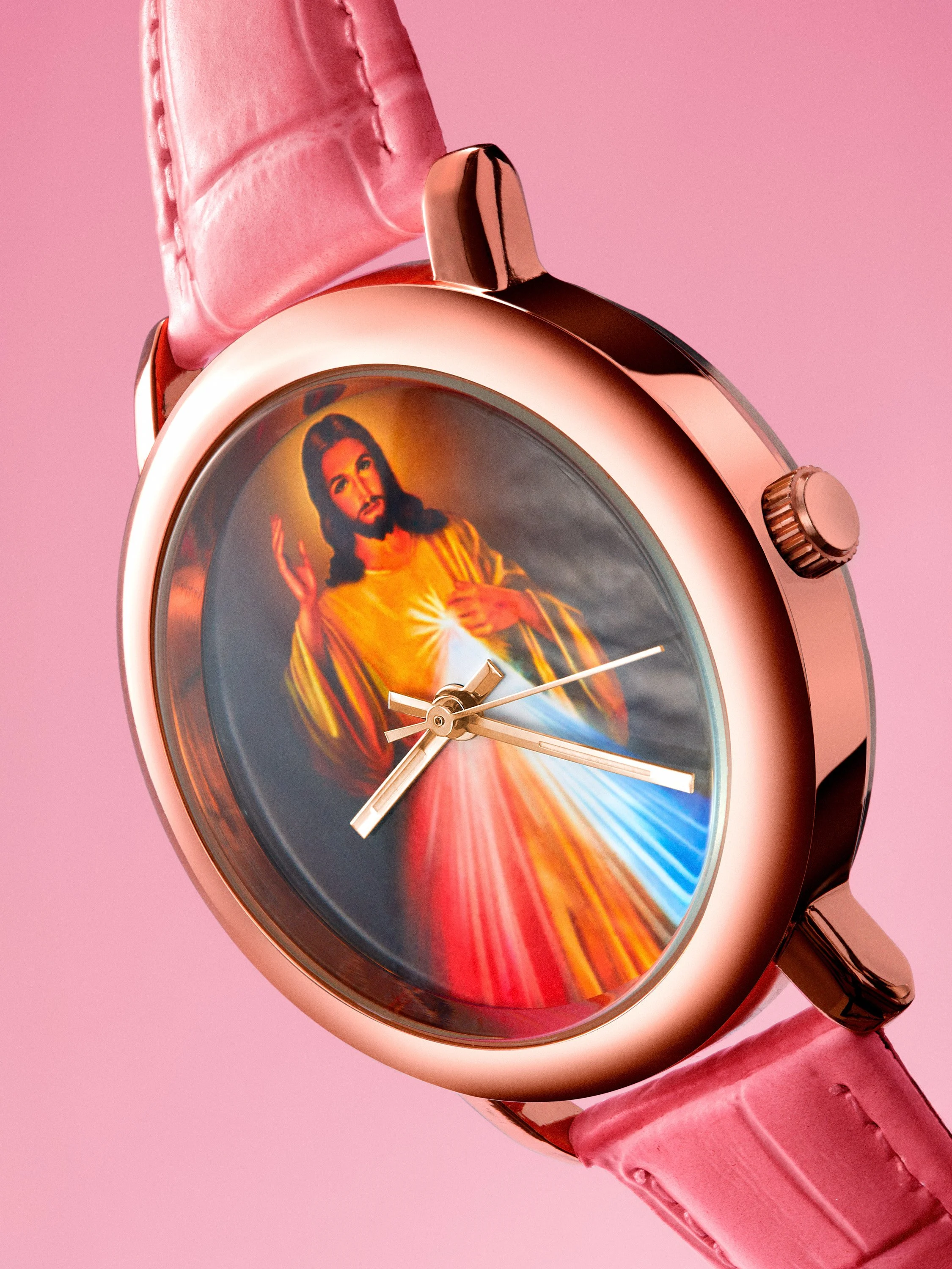 Montre connectée rose avec un écran affichant une image de Jésus-Christ avec une auréole de lumière et un fond coloré.