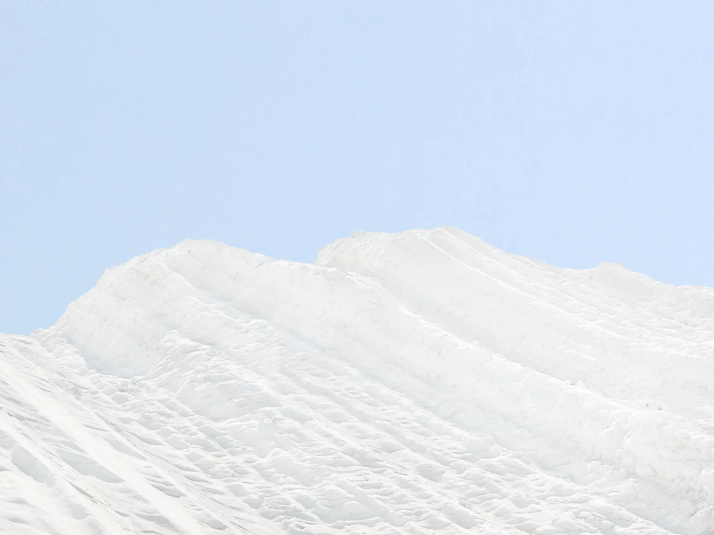 Montagne enneigée avec un ciel clair et bleu.