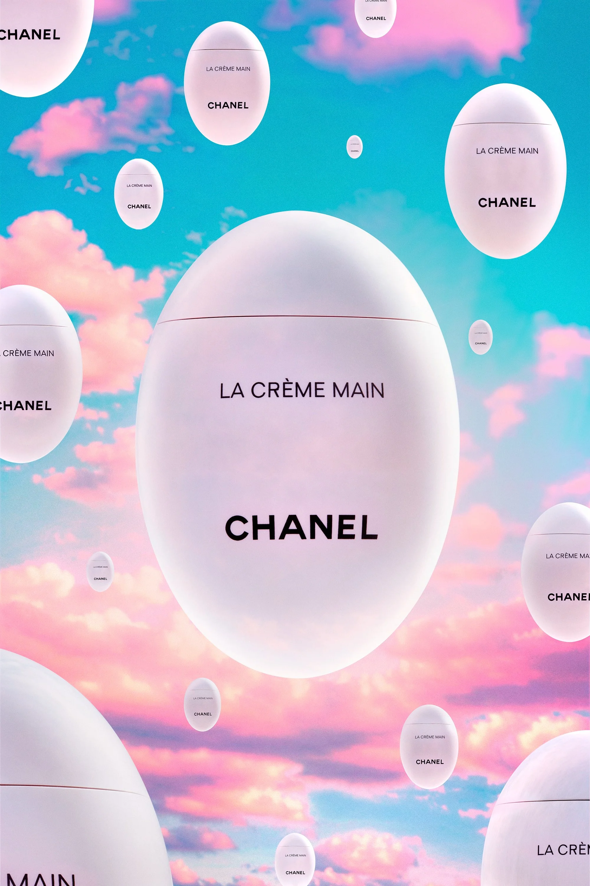 Affichage publicitaire avec des œufs de Pâques blancs portant l'inscription "LA CRÈME MAIN" et "CHANEL" flottant dans un ciel rose et bleu avec des nuages.