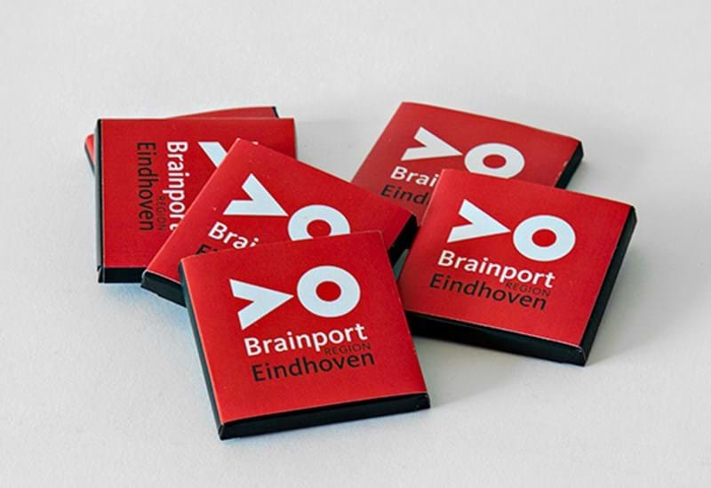 Five red Napolitains chocolate bars with the title 'Brainport Eindhoven' and the word 'Region' below, arranged on a white surface.