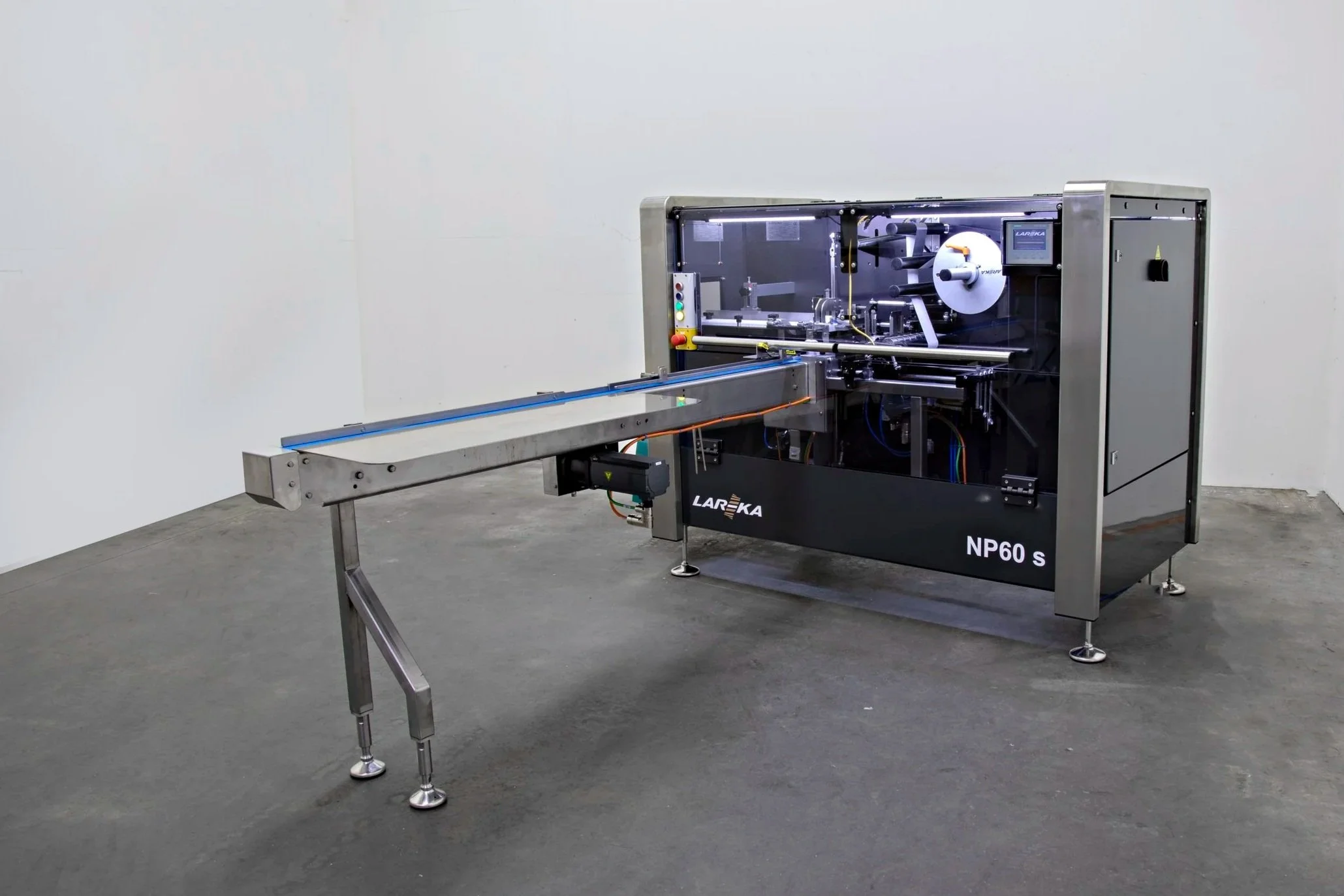 An NP60 chocolate packaging machine with metal components, control buttons, and a display screen in a room with plain walls and a concrete floor.