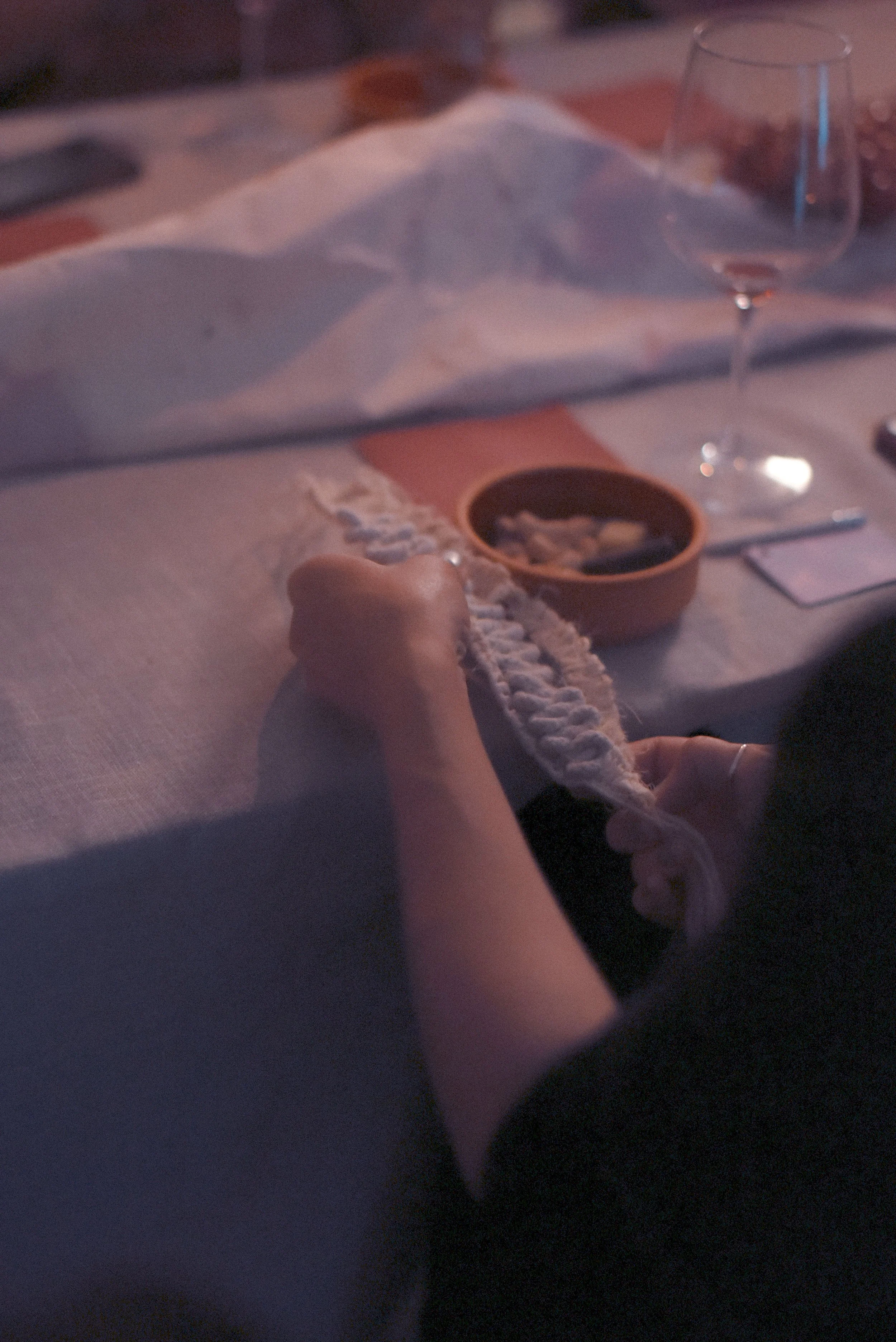 Detalle de manos manipulando un elemento textil durante el ritual de La Catarsis de la Uva.
