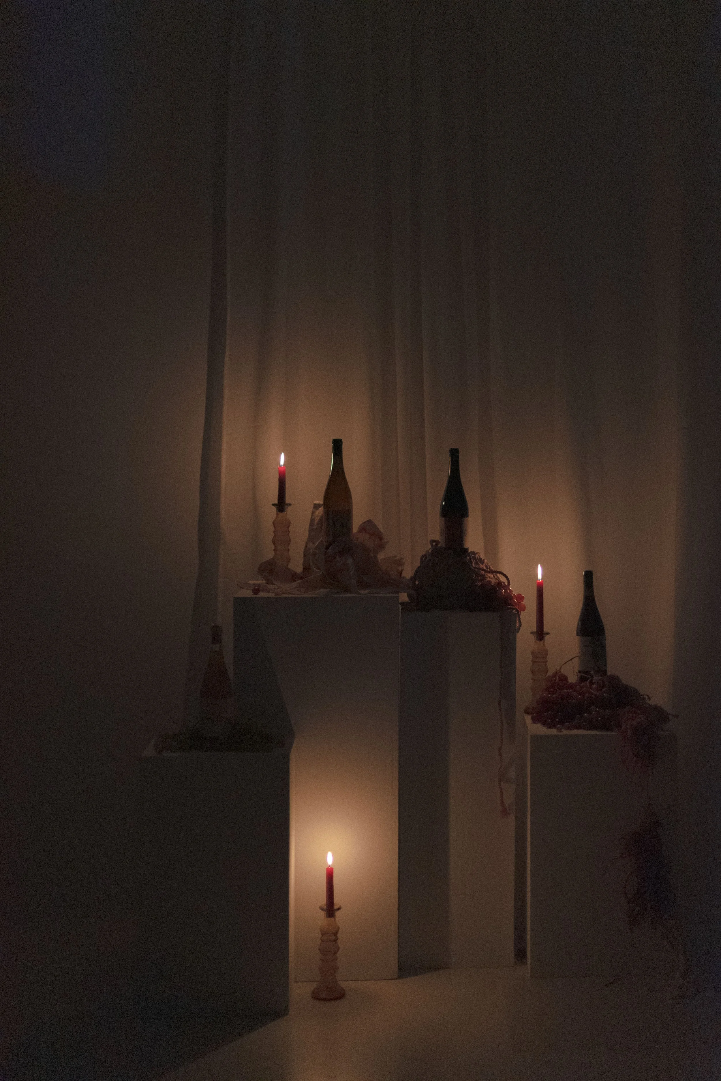 Instalación final con botellas, velas y elementos textiles de La Catarsis de la Uva.