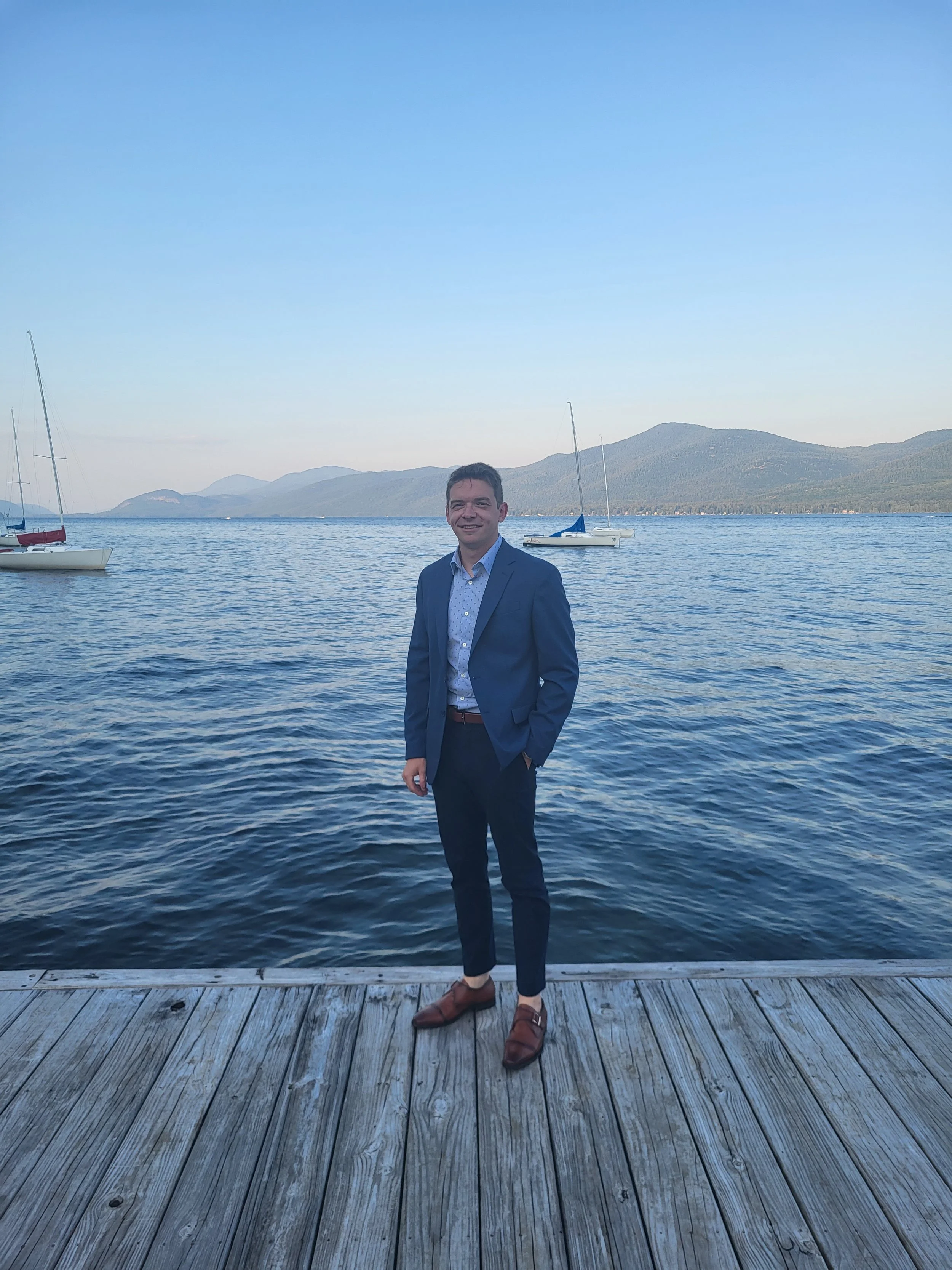 Picture of Tyler Moseman the founder of Concierge Lake George standing on the dock of the Lake George Club, a private club and wedding venue on Lake George located in Diamond Point, NY.
