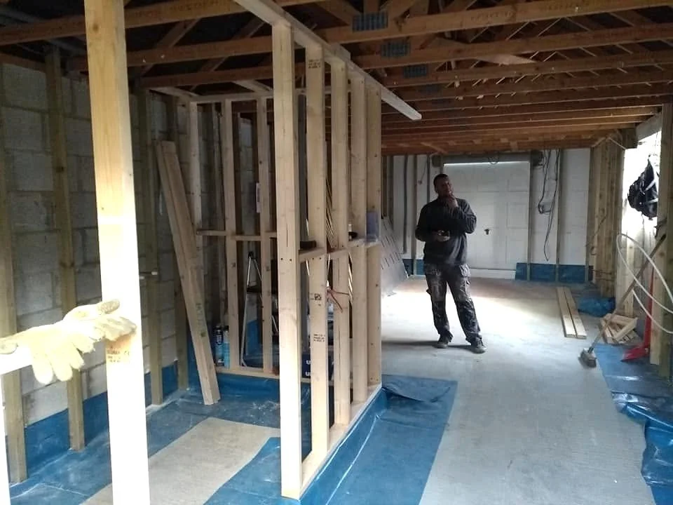 Garage conversion in progress, with timber stud partitions and exposed ceiling joists.