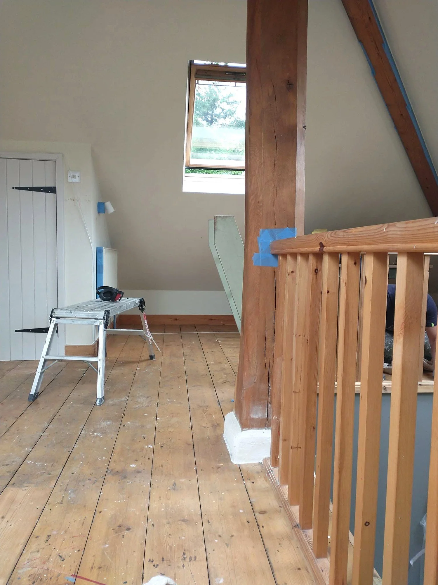 Timber mezzanine balustrade before painting, with masking tape protecting the adjoining exposed wooden post.