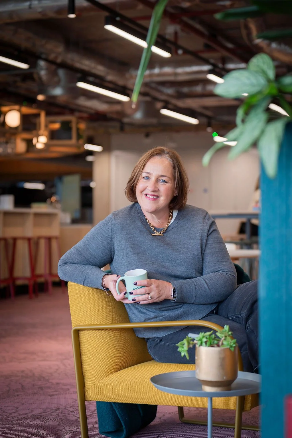 SaaS and tech business recruitment specialist sitting on yellow chair in office