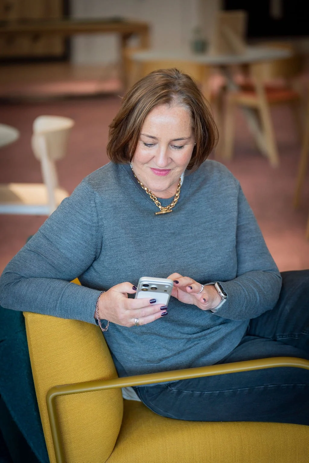 Technology talent acquisition and recruitment specialist sitting on yellow chair on mobile phone