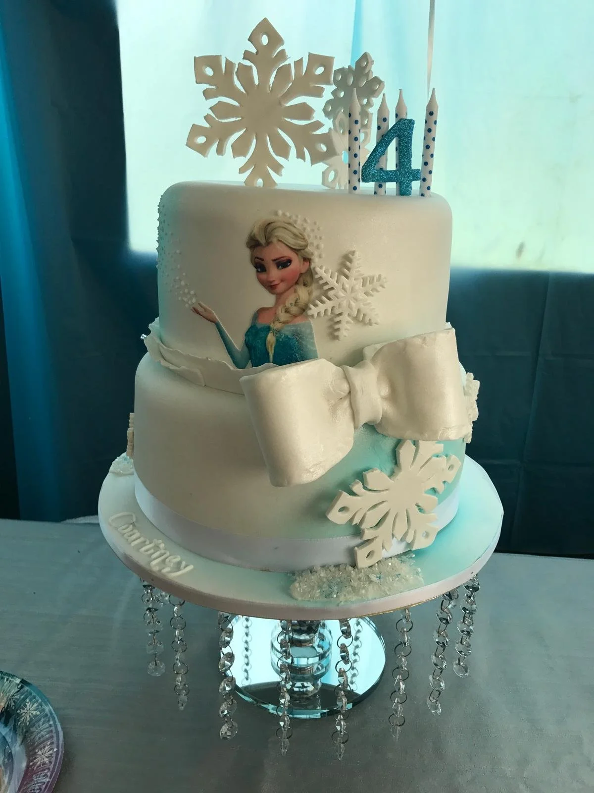 Frozen-themed children's cake with snowflakes and a bow